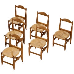 Guillerme & Chambron Ensemble de six chaises de salle à manger en chêne massif et jonc