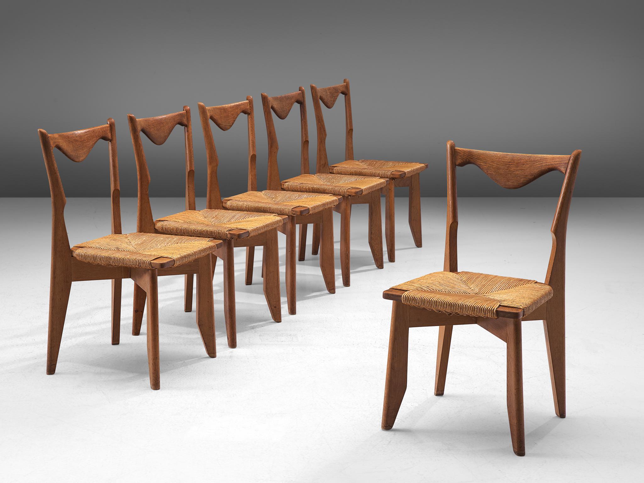 Guillerme & Chambron for Votre Maison, model Thibault, dining chairs, oak and rope, France, 1960s.

Set of six elegant dining chairs in solid oak by Guillerme and Chambron. These chairs have characteristic frames with tapered legs and a sculptural