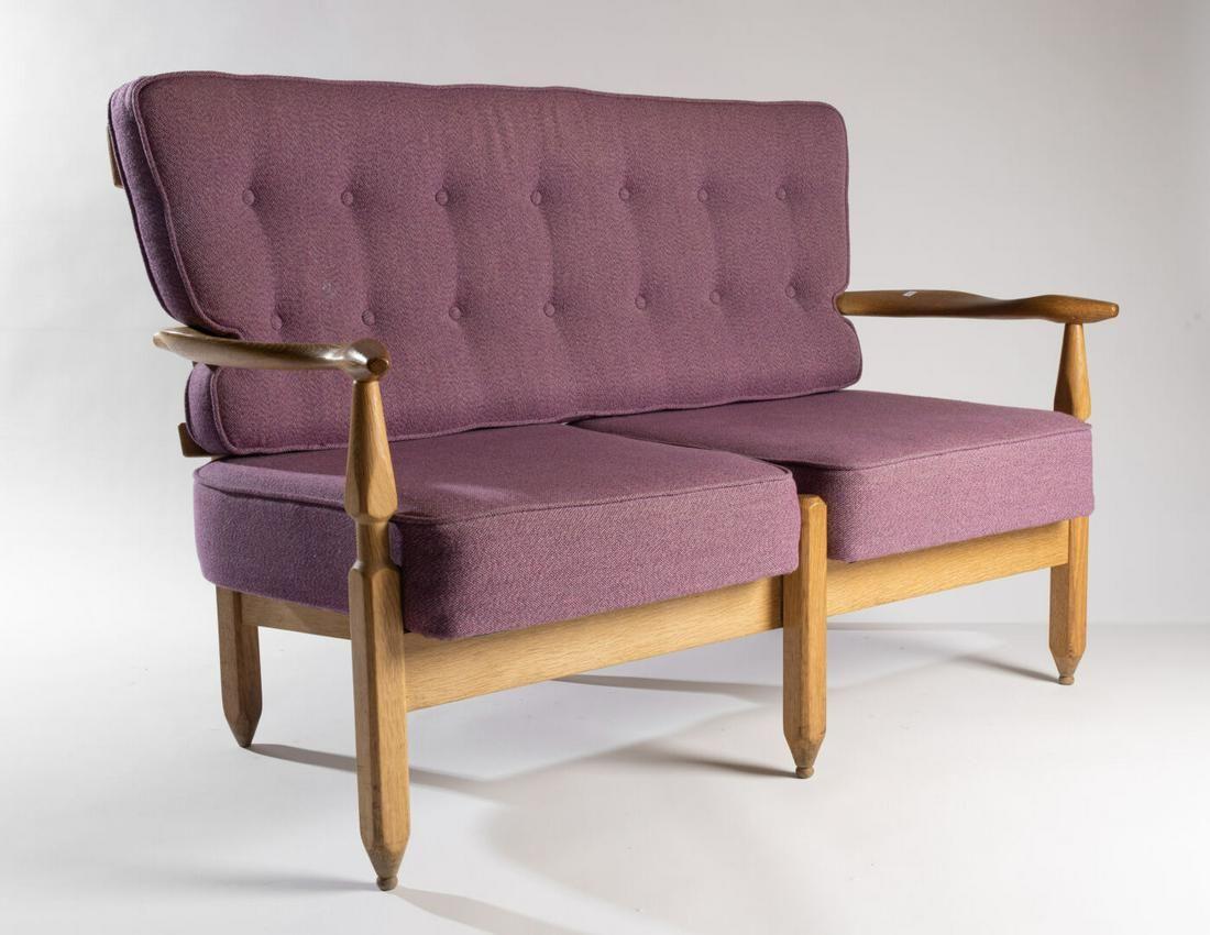 This settee was designed by the iconic French design duo Guillerme et Chambron. The high quality and distinctive skeletal open frame construction features a beautifully crafted spindle back, sculptural arm rests, and notched, turned and planed