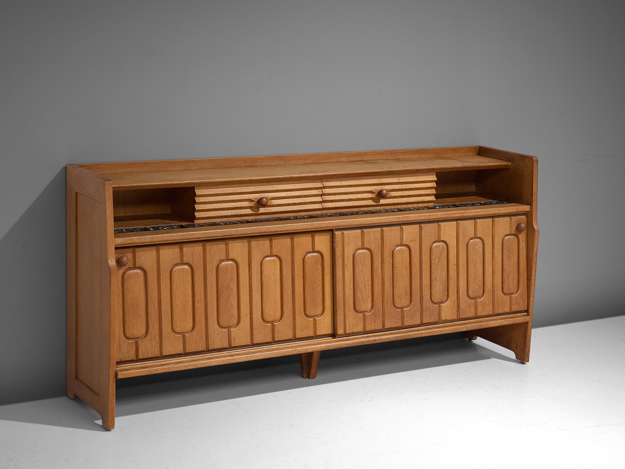 Guillerme et Chambron, sideboard, oak, ceramic, France, 1960s

Credenza in oak by French designer due Guillerme & Chambron. This sideboard is equipped with two sliding-doors and a set of drawers. The front of the sideboard is beautifully detailed