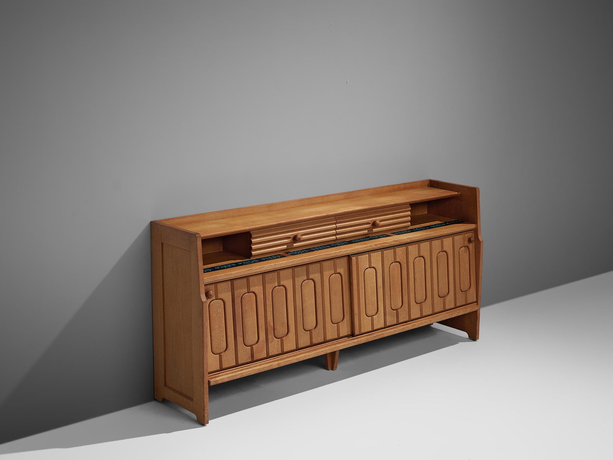 Guillerme et Chambron for Votre Maison, sideboard, oak, ceramic, France, 1960s

Credenza in oak by French designer duo Guillerme & Chambron. This sideboard is equipped with two sliding-doors below, and the upper part contains two smaller sliding