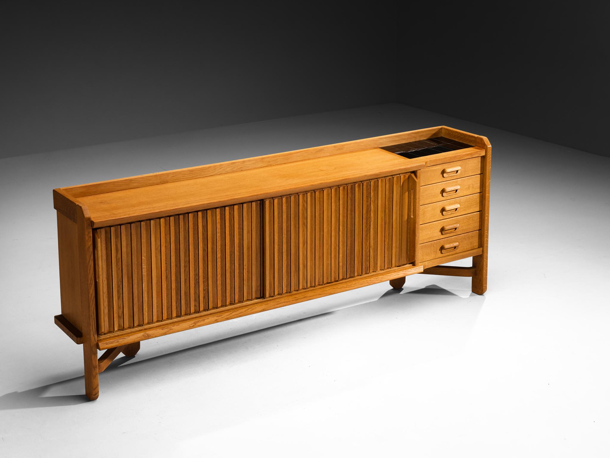 Guillerme et Chambron for Votre Maison, 'Saint Véran' credenza, solid oak, ceramic, France, 1960s

This charming Saint Véran sideboard, designed by the talented designer duo Guillerme et Chambron, stands out with its solid construction, exquisite