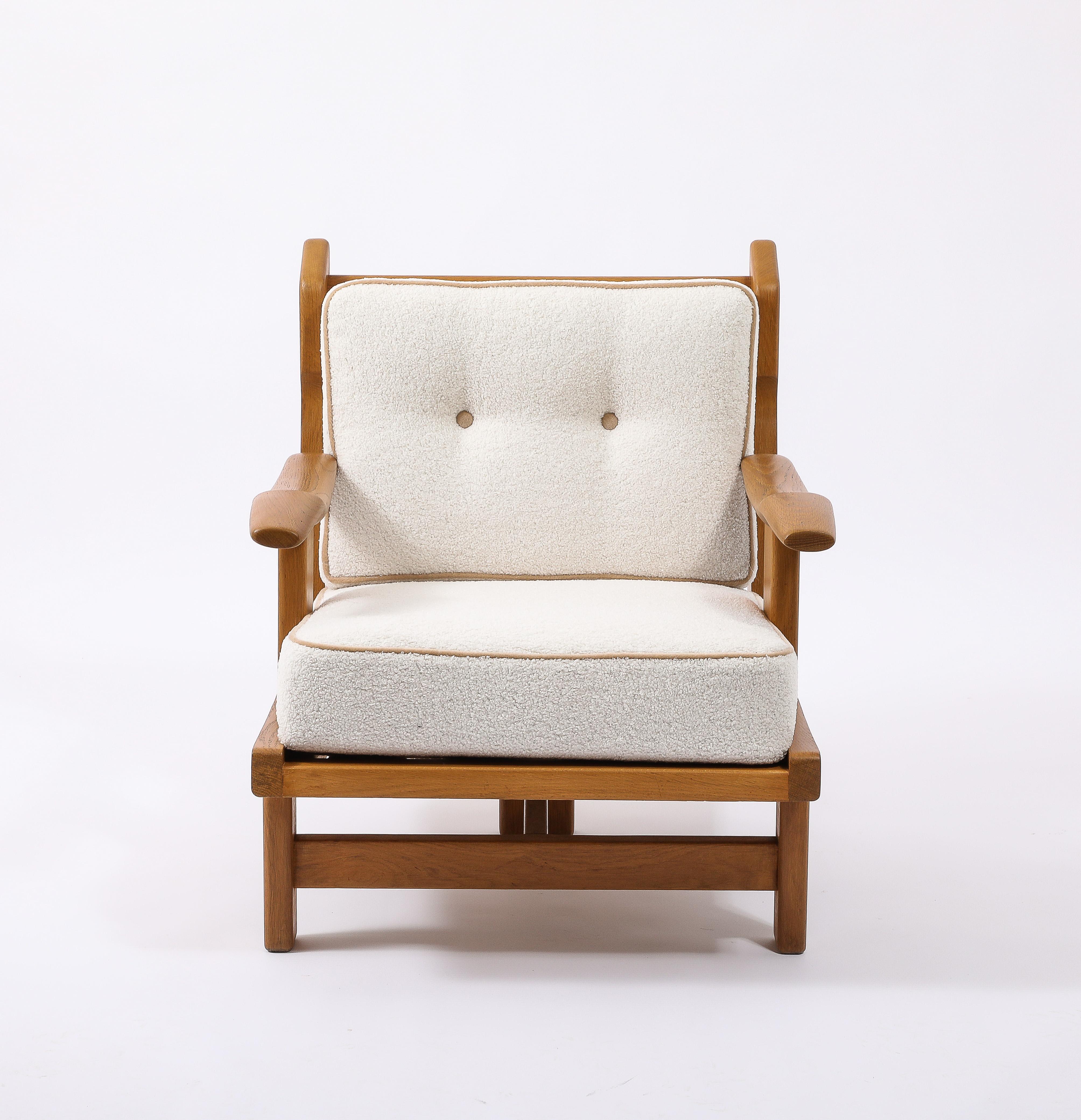 Rare and comfortable Tripod Oak armchair with separated arms. Refinished and reupholstered in a Pierre Frey Bouclé with contrasting piping and buttons.

