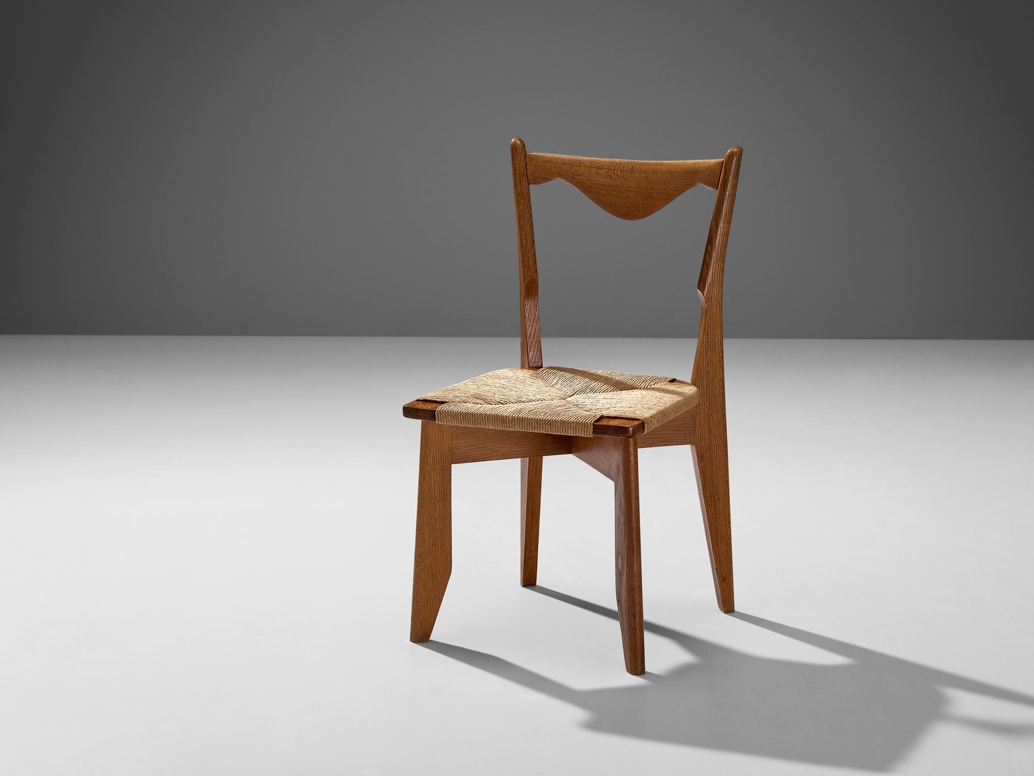 Guillerme et Chambron for Votre Maison, 'Thibault' dining chair, oak, papercord, France, 1960s

Elegant chair in solid oak by Guillerme and Chambron. This chair shows a characteristic frame by this French designer duo known for their oak sculptural