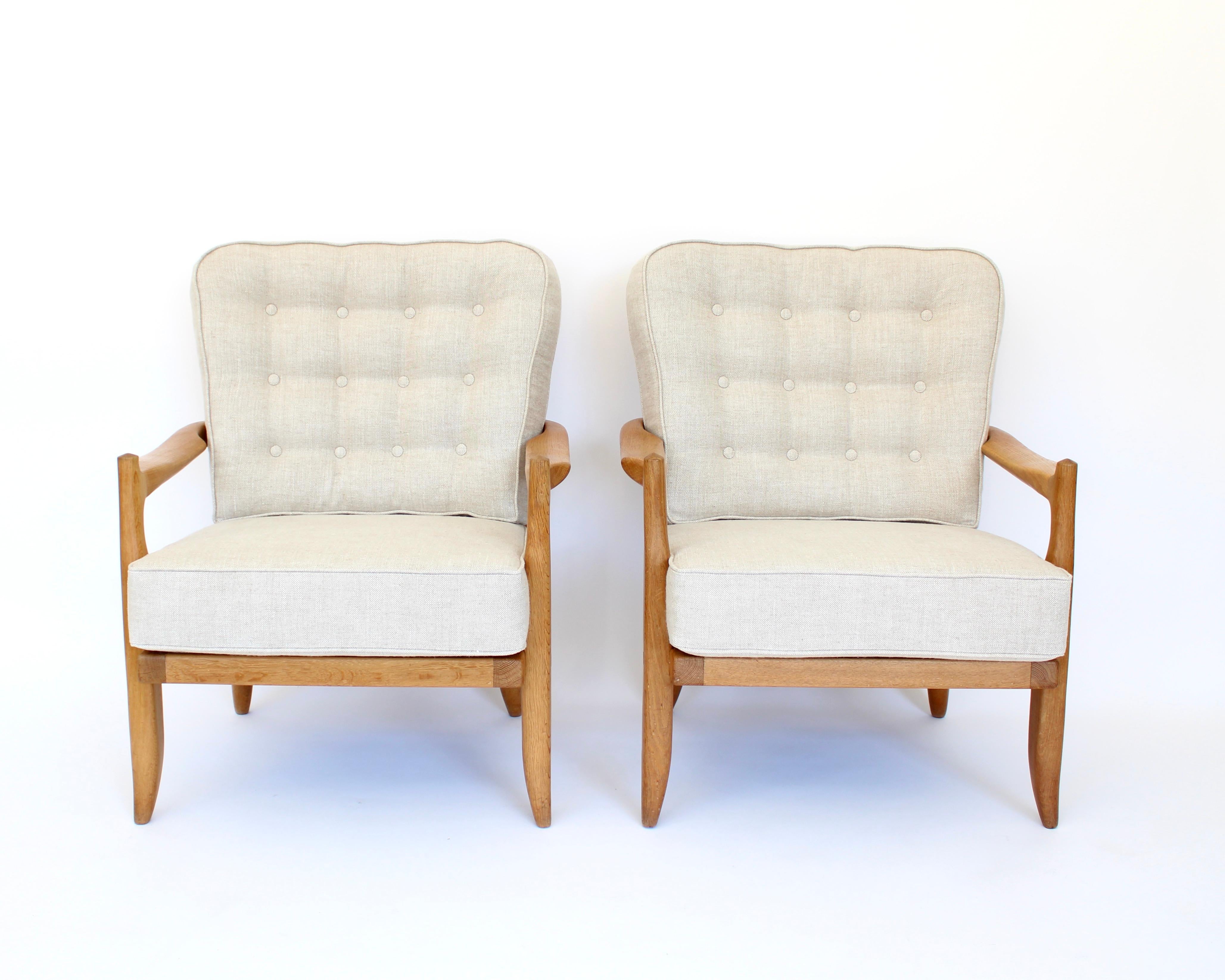 Two French Gullerme et Chambron or Guillerme and Chambron lounge chairs model Jose in natural oak for Votre Maison. 
This pair of the model Jose lounge chairs have a very sculptural back not seen on other models of Chambron chairs and have an