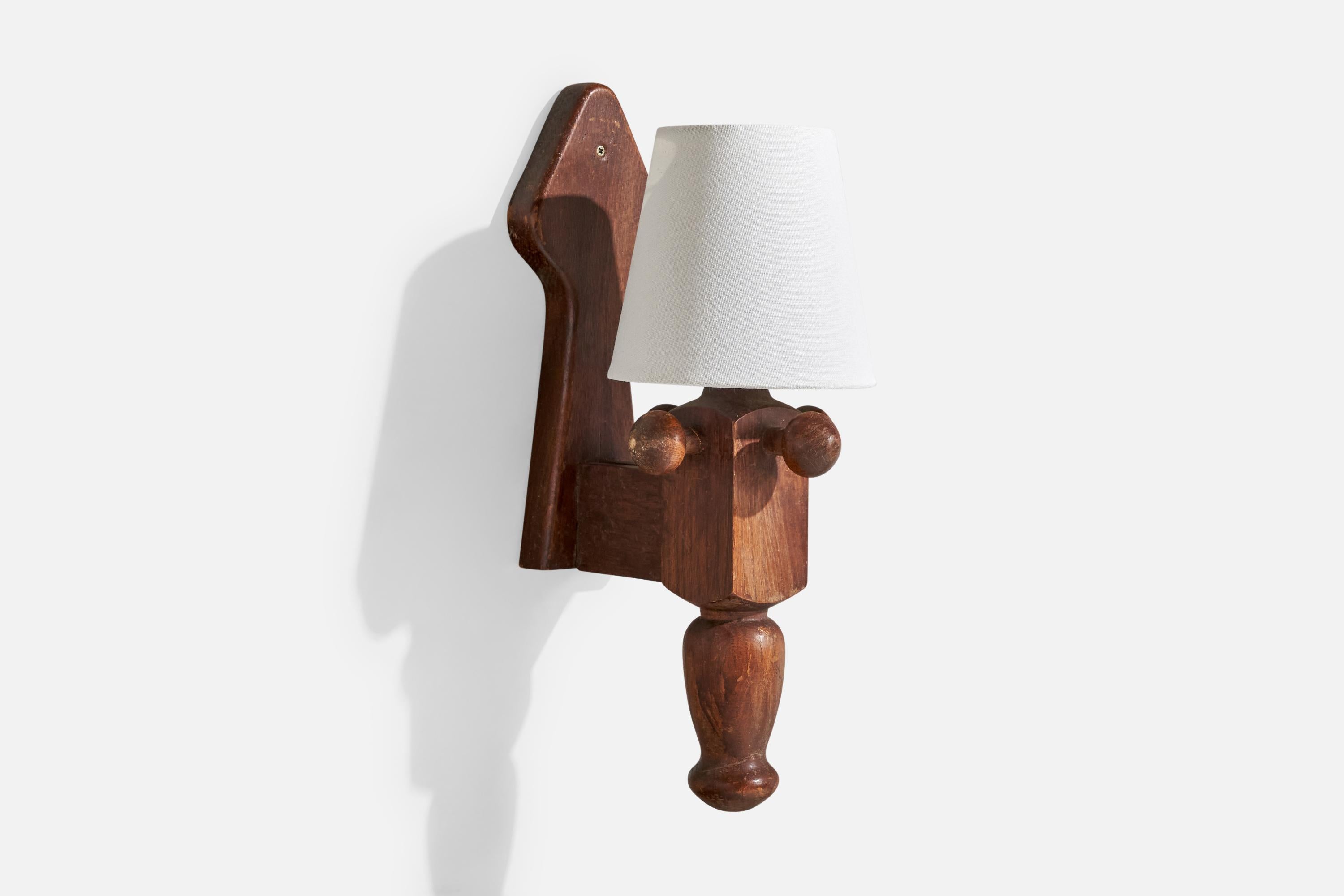 A dark-stained oak and white fabric wall light produced by Guillerme & Chambron, France, c. 1960s.

The fixture presents with moderate scratching and discoloration throughout the wood.

Overall Dimensions (Inches): 16.25” H x 5.9” W x 8.8” D

Back