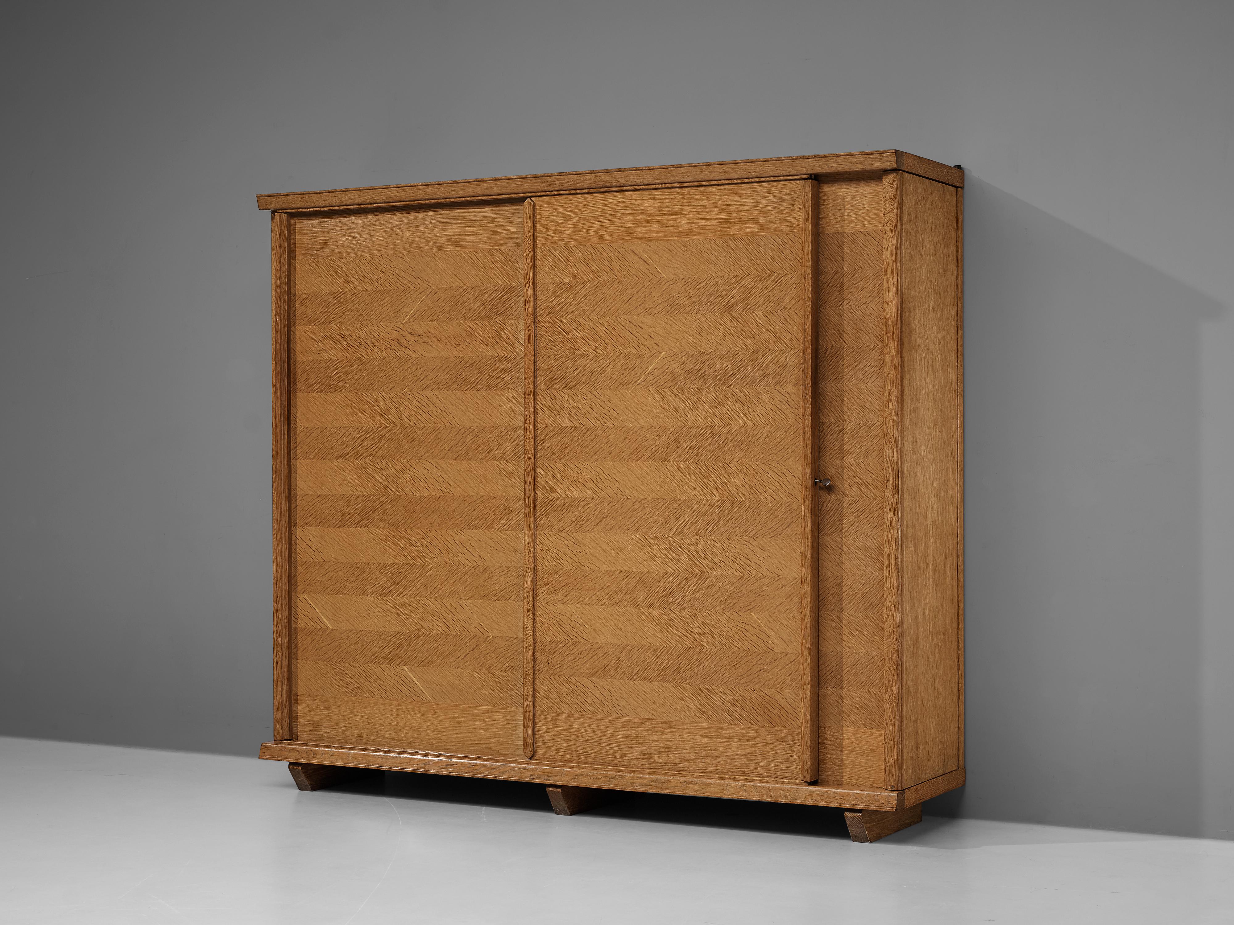 Guillerme & Chambron, wardrobe, oak, France, 1960s

This grand wardrobe is made in beautiful blonde oak wood in a flattering horizontal pattern in a darker and lighter wood. It was designed by duo Guillerme and Chambron in the 1960s. The two doors