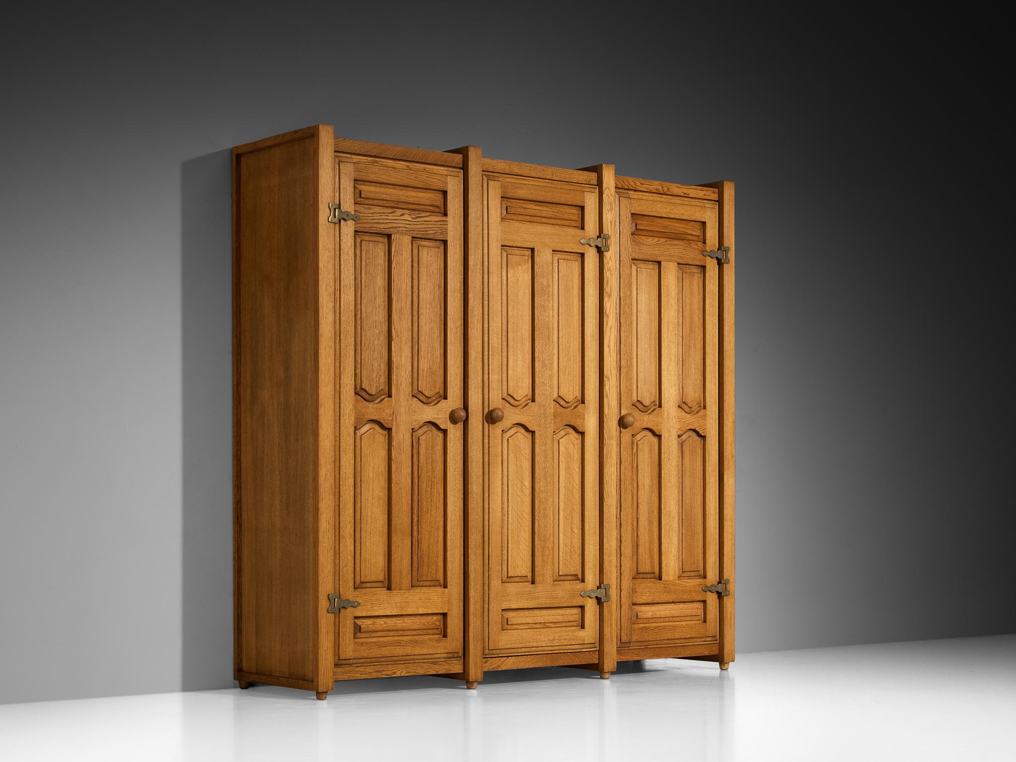 Guillerme & Chambron for Votre Maison, armoire or wardrobe, oak, brass, France, 1960s

This charming wardrobe is a good example of excellent woodworking by virtue of the graphical designed door panels illustrating geometrical wooden carvings, which