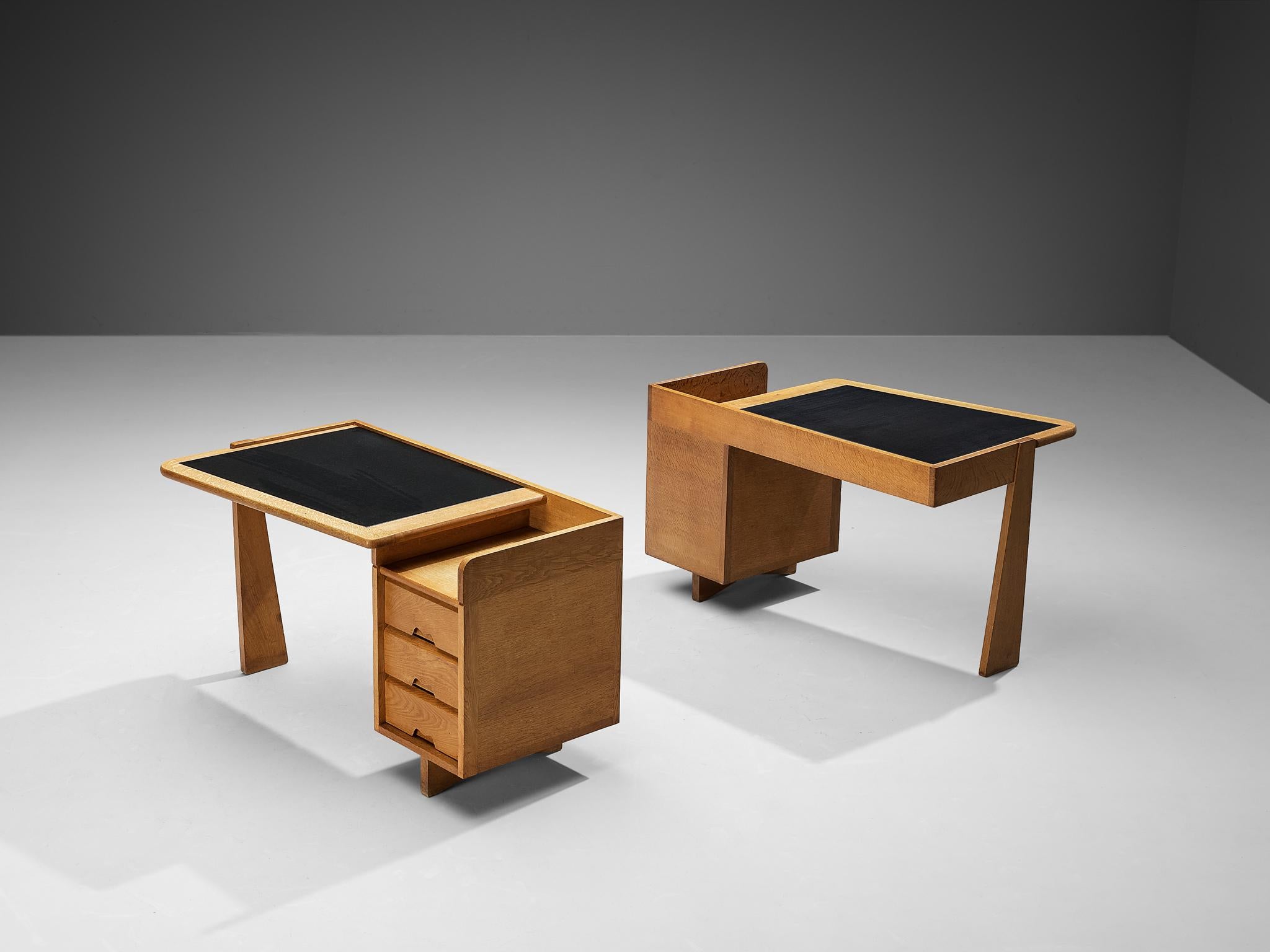 Guillerme et Chambron for Votre Maison, writing desks, oak, leather, France, 1960s.

This set of desks is designed by the renowned French duo Guillerme et Chambron. This design holds an utterly well-balanced construction supported by the