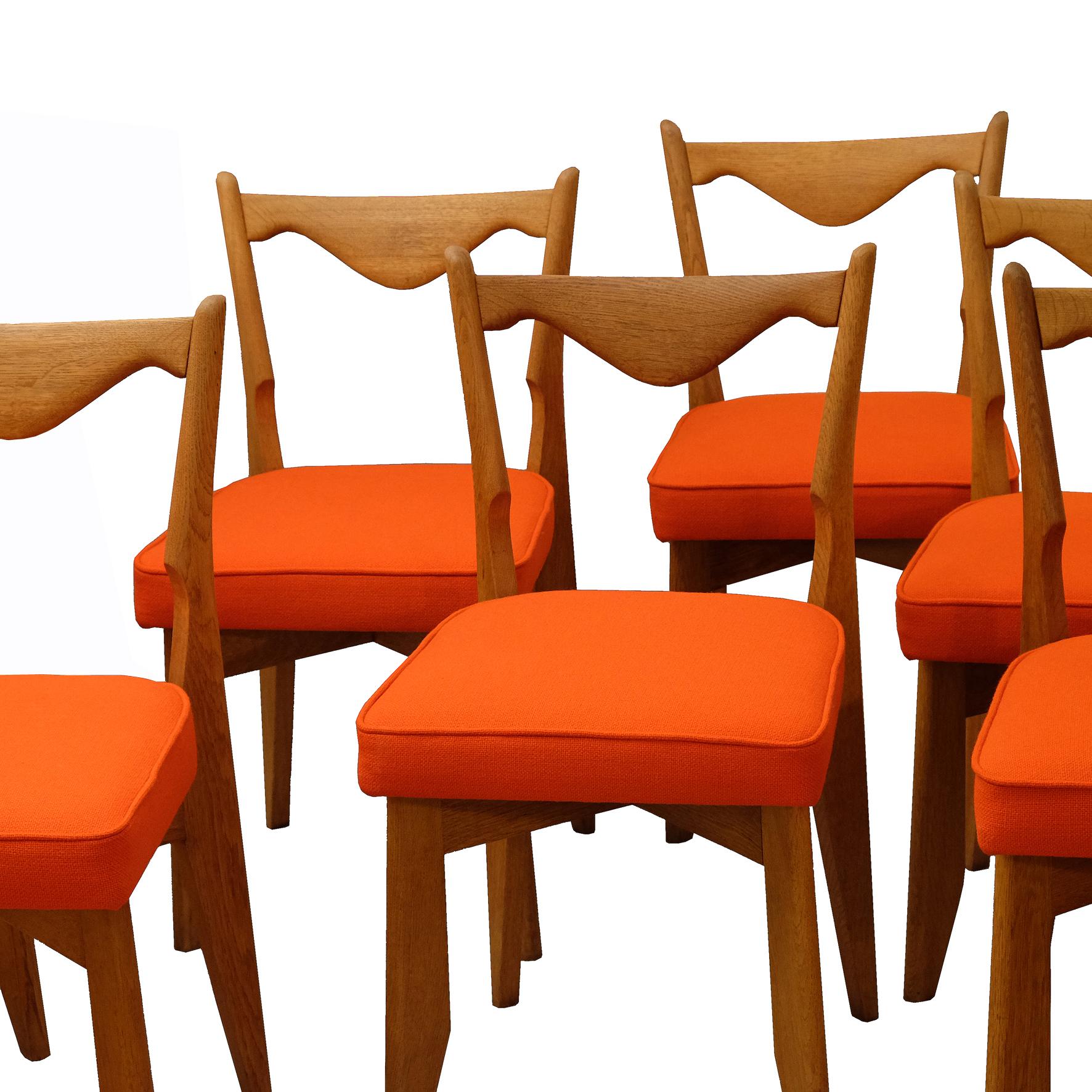 A set of six carved oak chairs.
The seat cushions covered with orange wool fabric.
The four saber shaped feet joined by a crosspiece under the seat.

These beautiful pieces by the acclaimed pair of French designers were perfectly reupholstered