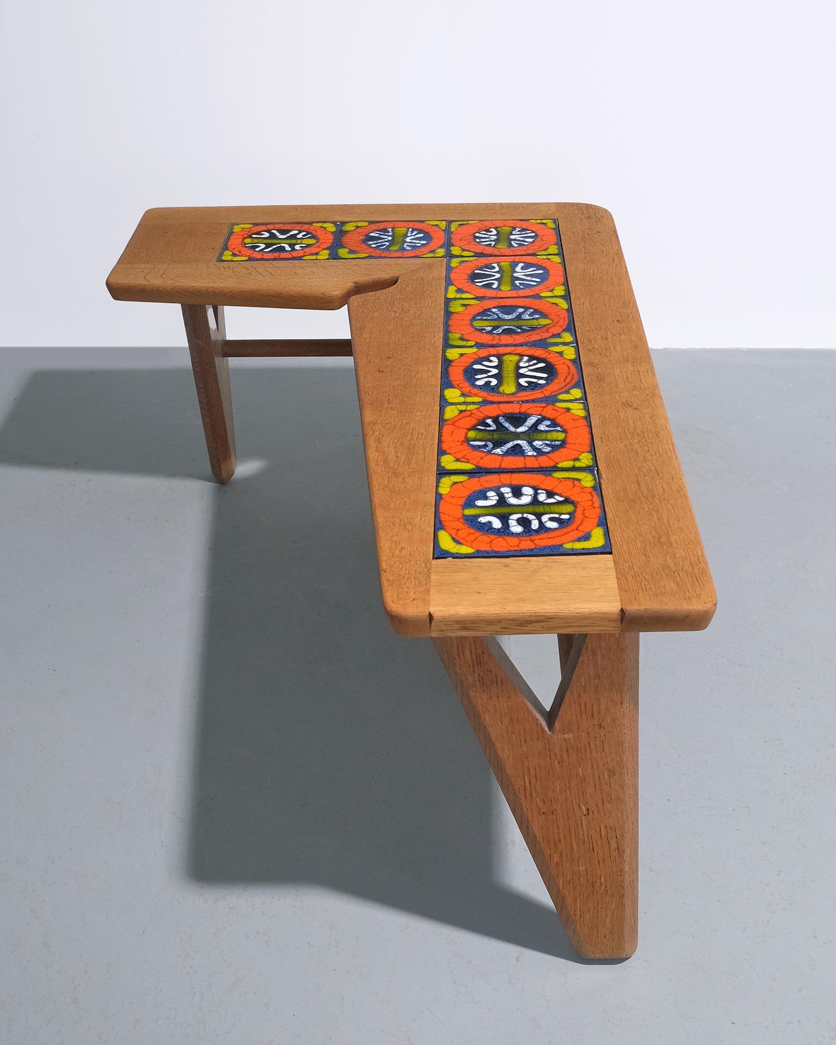 ‘Boomerang’ coffee table by Guillerme et Chambron for Edition Votre Maison, France, c.1960–1970. Crafted in waxed oak with a distinctive boomerang-shaped top, the table features an inset panel of hand-glazed ceramic tiles. The sculptural base