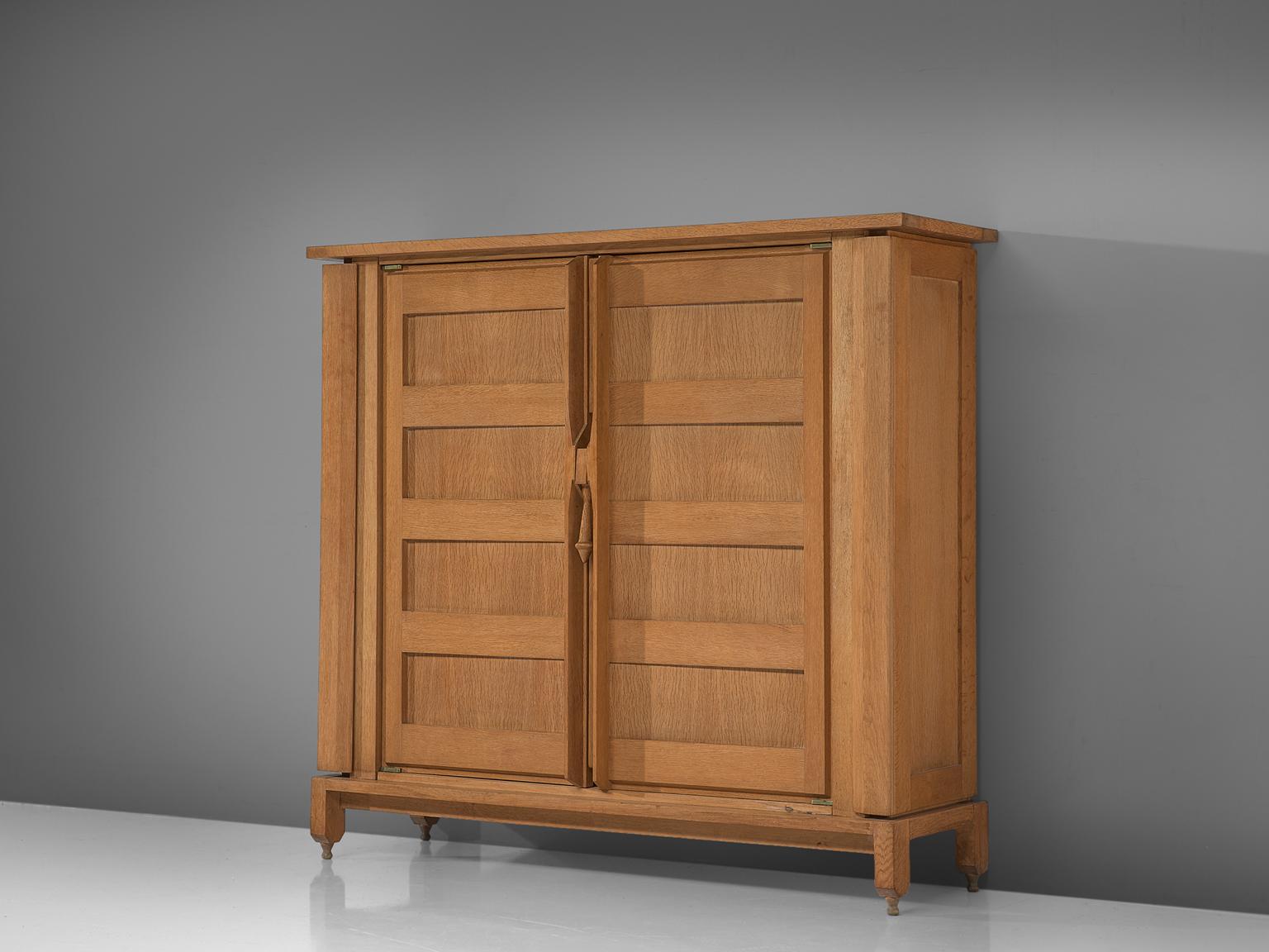 Guillerme and Chambron for Votre Maison, cabinet, oak, France, circa 1970.

This case piece is designed by Guillerme and Chambron and features geometric engravings in the doors. The cabinet offers plenty of storage, including 'hidden' compartments
