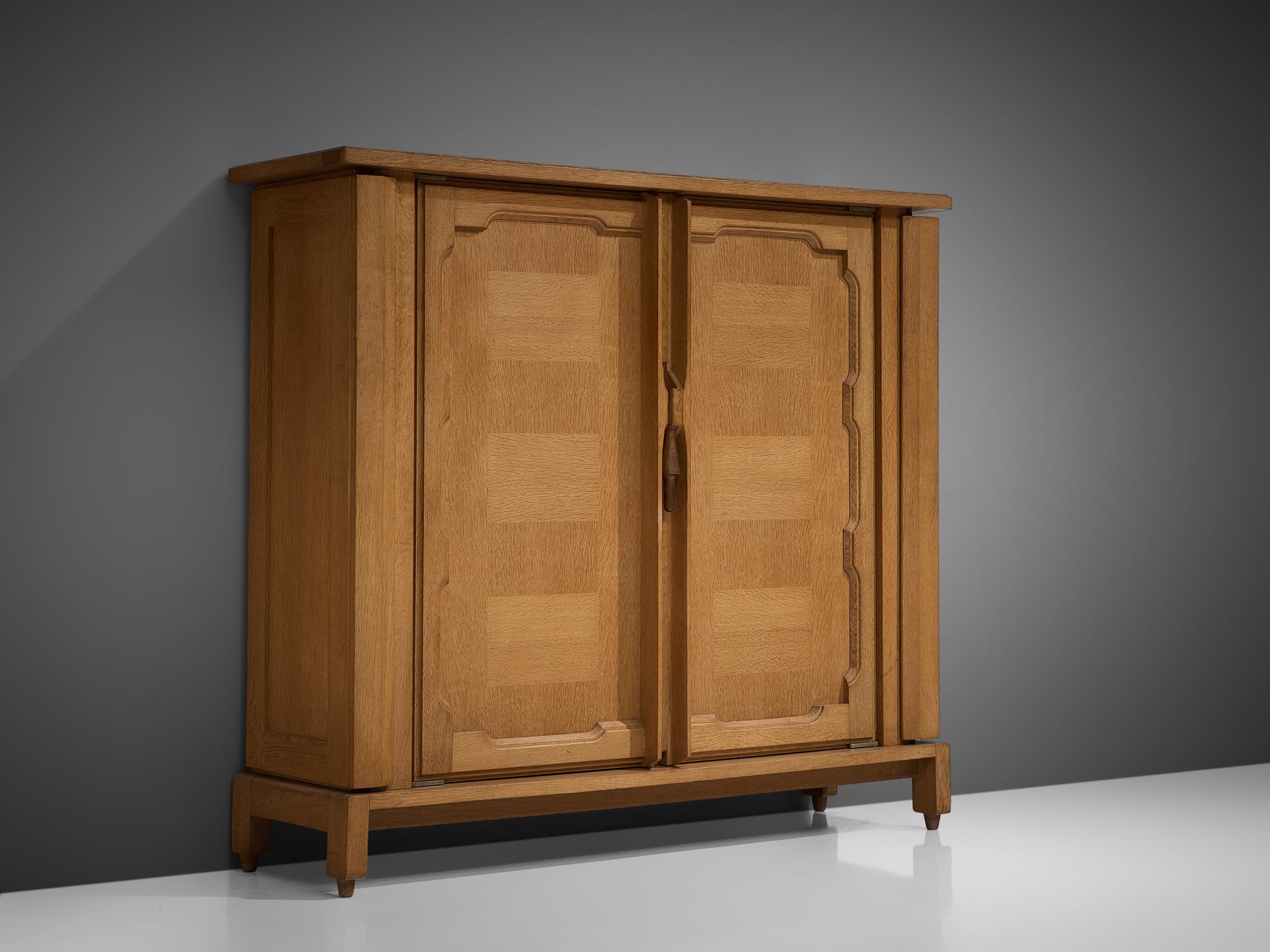 Guillerme and Chambron for Votre Maison, 'Bouviene' cabinet, oak, France, circa 1970.

This case piece is designed by Guillerme and Chambron and features geometric inlays in the doors. The cabinet offers plenty of storage, with a large compartment