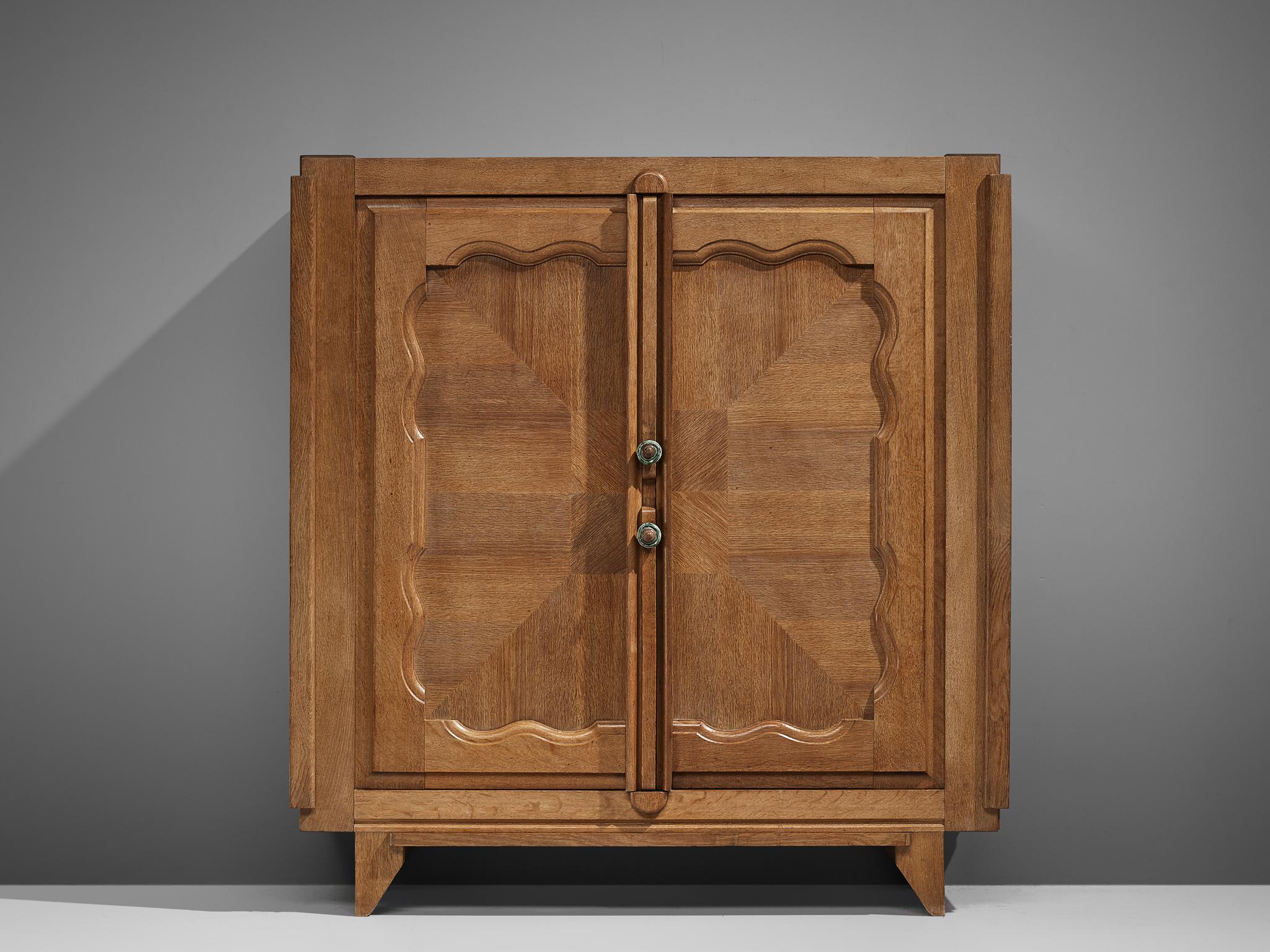 Guillerme and Chambron for Votre Maison, 'Bouviene' cabinet, oak, France, circa 1970.

This case piece is designed by Guillerme and Chambron and features geometric inlays in the doors. The cabinet offers plenty of storage, with a large compartment