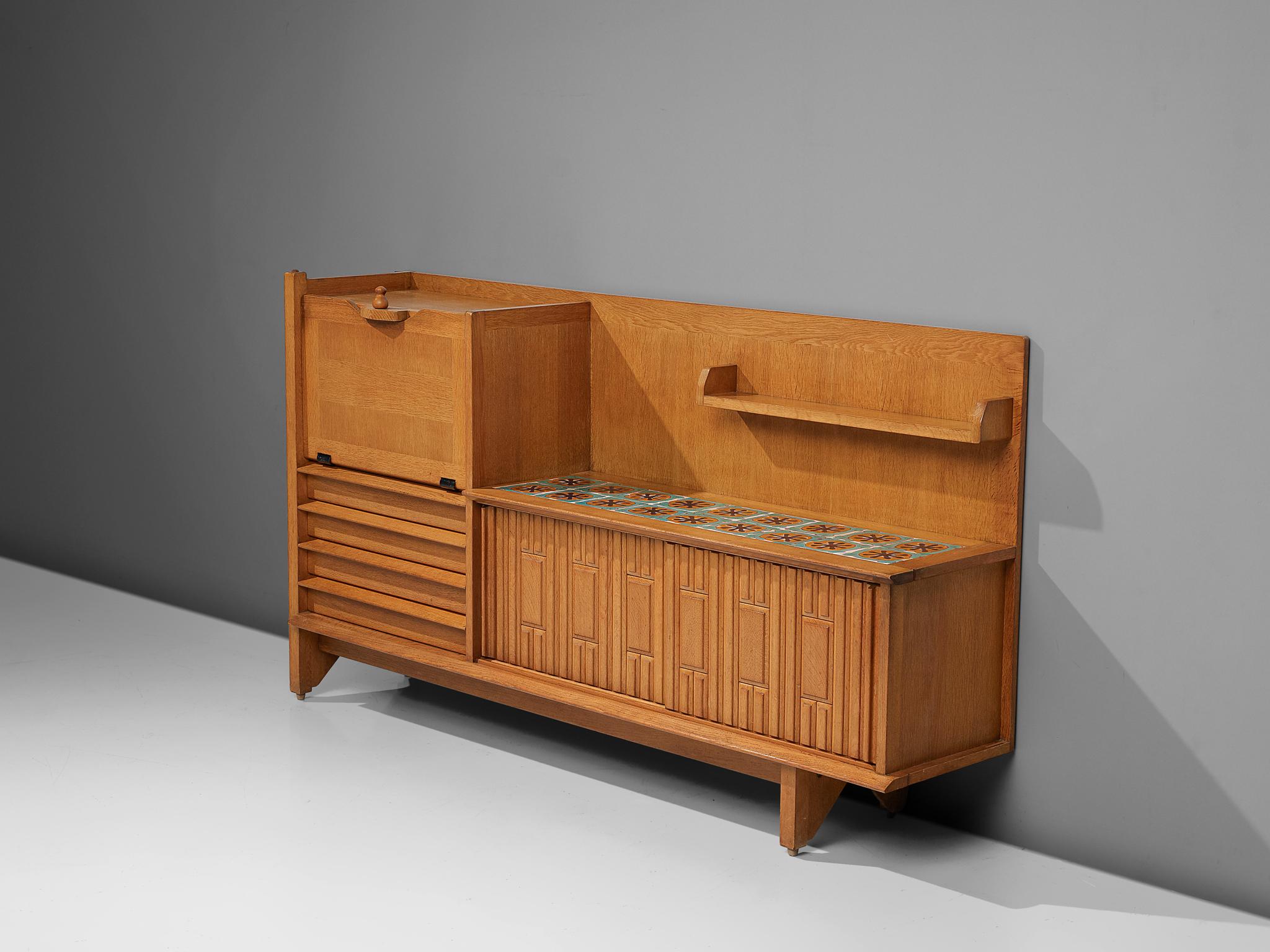 Guillerme et Chambron, buffet, oak and ceramic, France, 1960s

This characteristic cabinet in solid oak is designed by the French designer duo Jacques Chambron (1914-2001) and Robert Guillerme (1913-1990). It features two sliding front doors, one