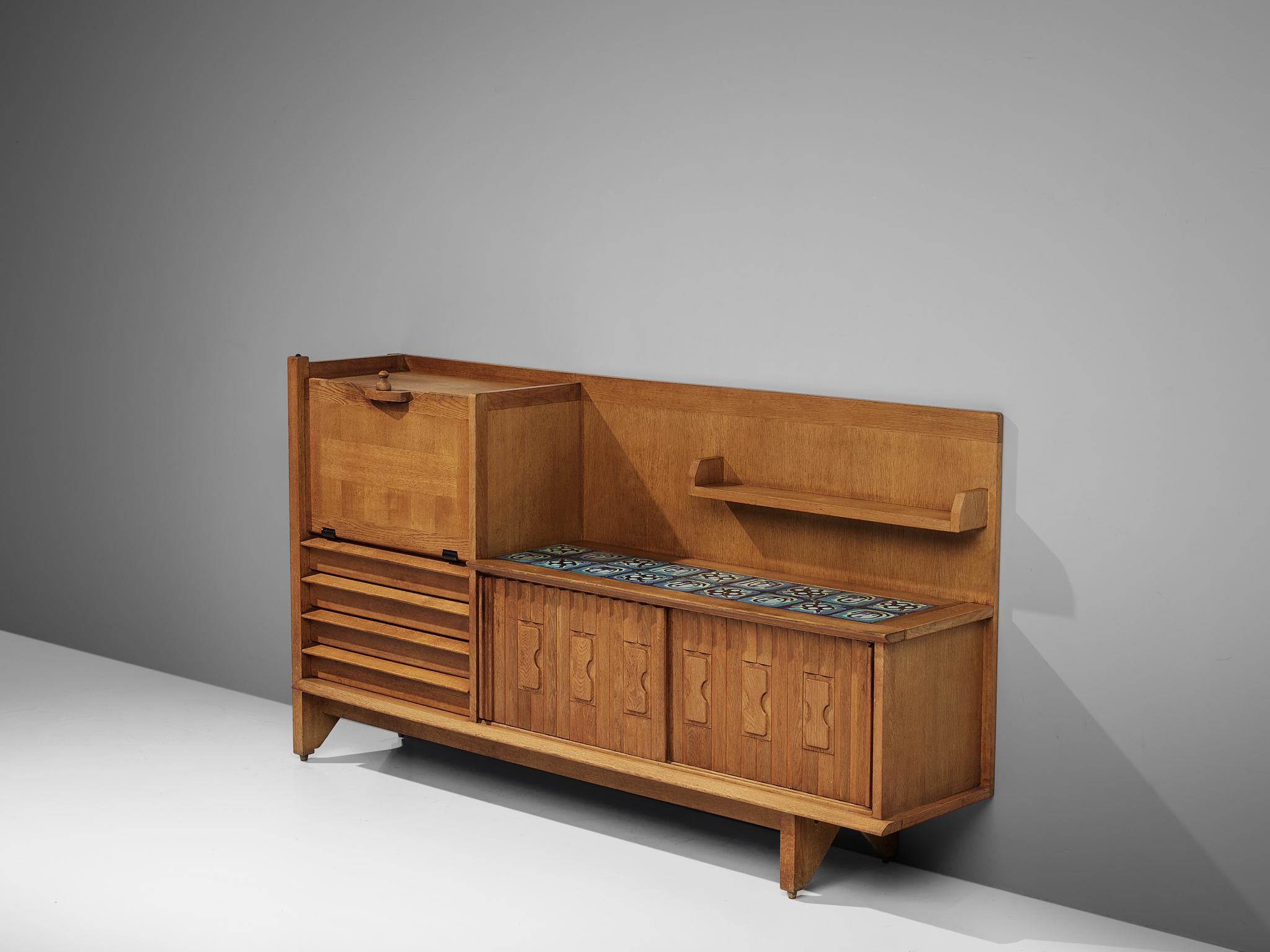 Guillerme et Chambron, buffet, oak and ceramic, France, 1960s

This characteristic cabinet in solid oak is designed by the French designer duo Jacques Chambron and Robert Guillerme. It features two sliding front doors, one pullout doors on the