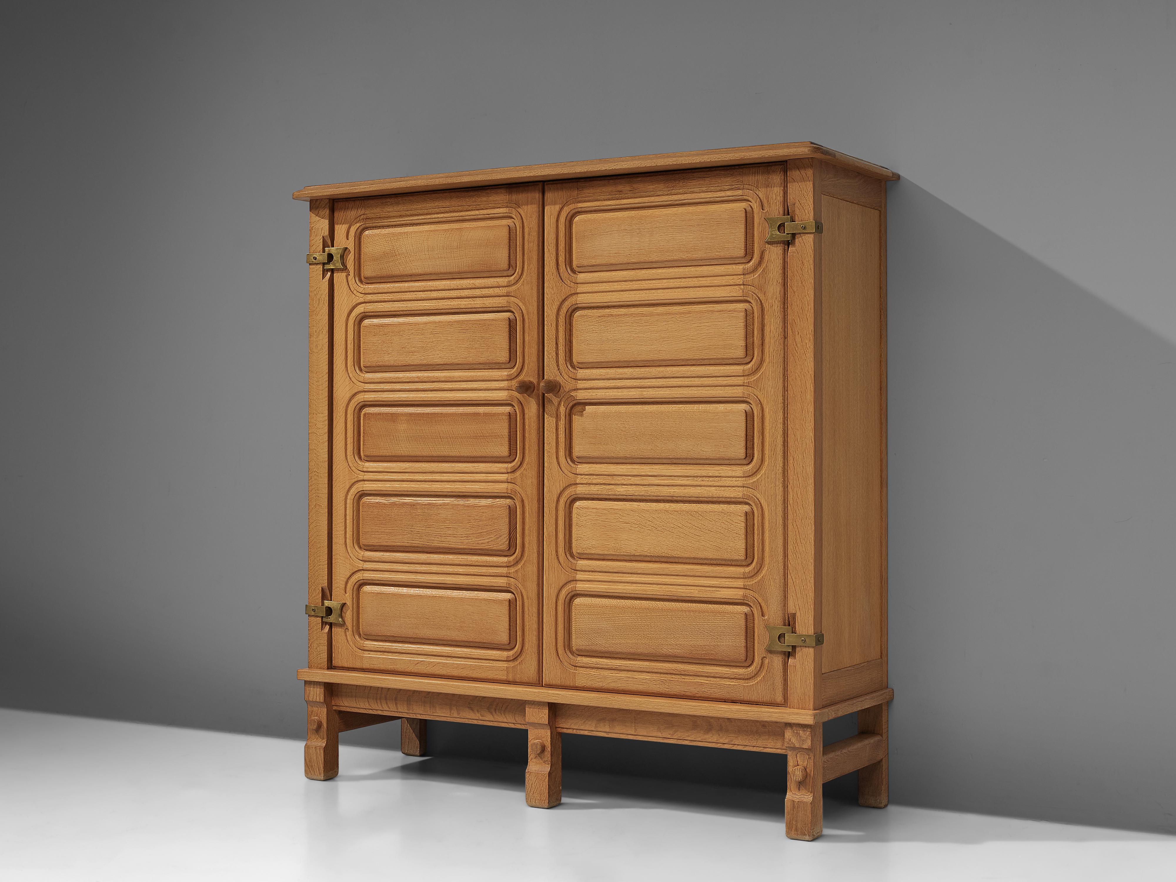Guillerme et Chambron for Votre Maison, cabinet, oak, brass, France, 1970s.

This case piece is designed by Guillerme and Chambron and features a decorative design in the doors. The cabinet offers plenty of storage, with three shelves on both