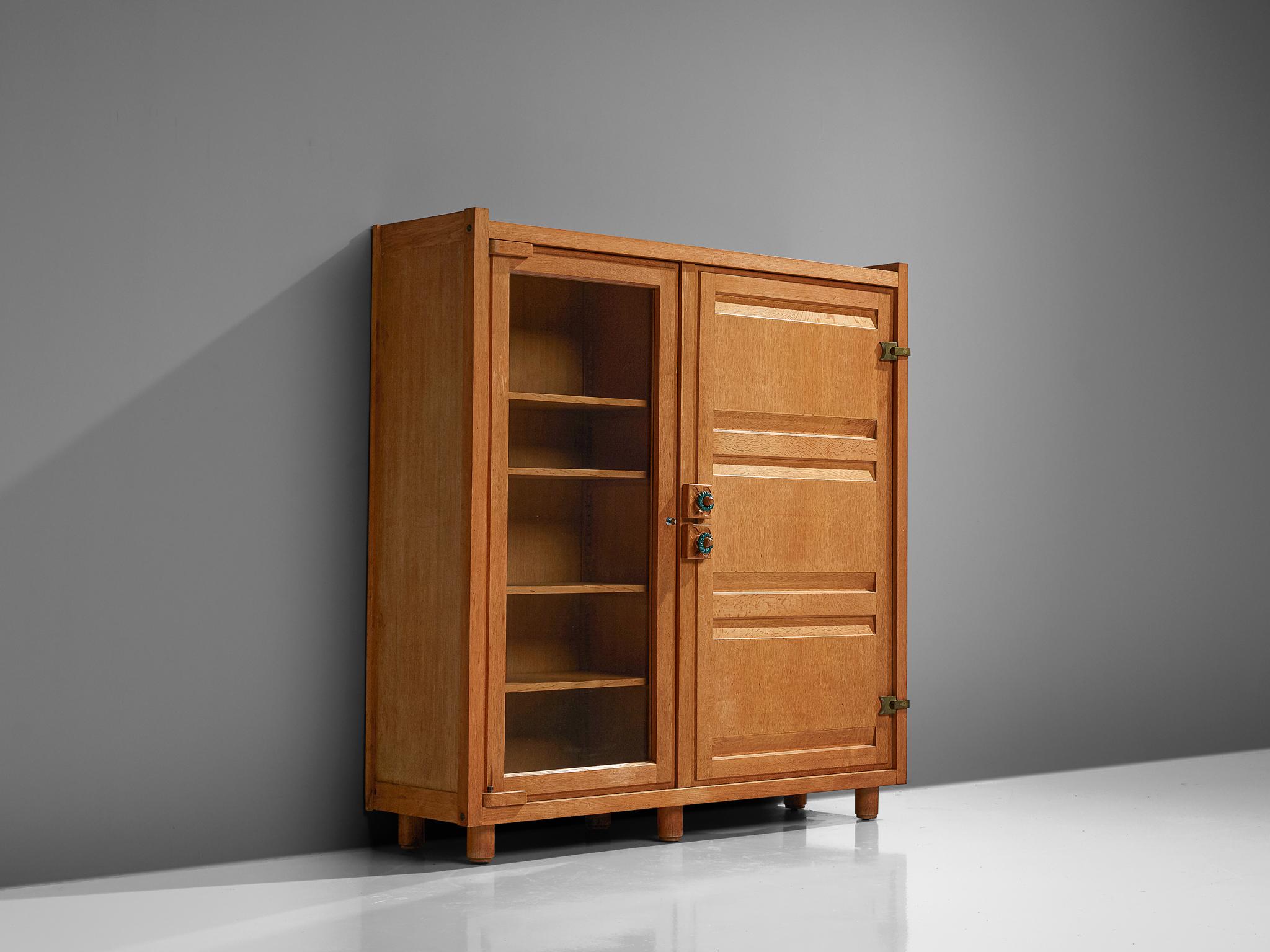 Guillerme et Chambron, armoire, oak, ceramics and glass, France, 1960s.

This case piece is designed by Guillerme and Chambron and features geometric oak inlays, which is characteristic for the French duo. The glass door makes this vitrine perfect