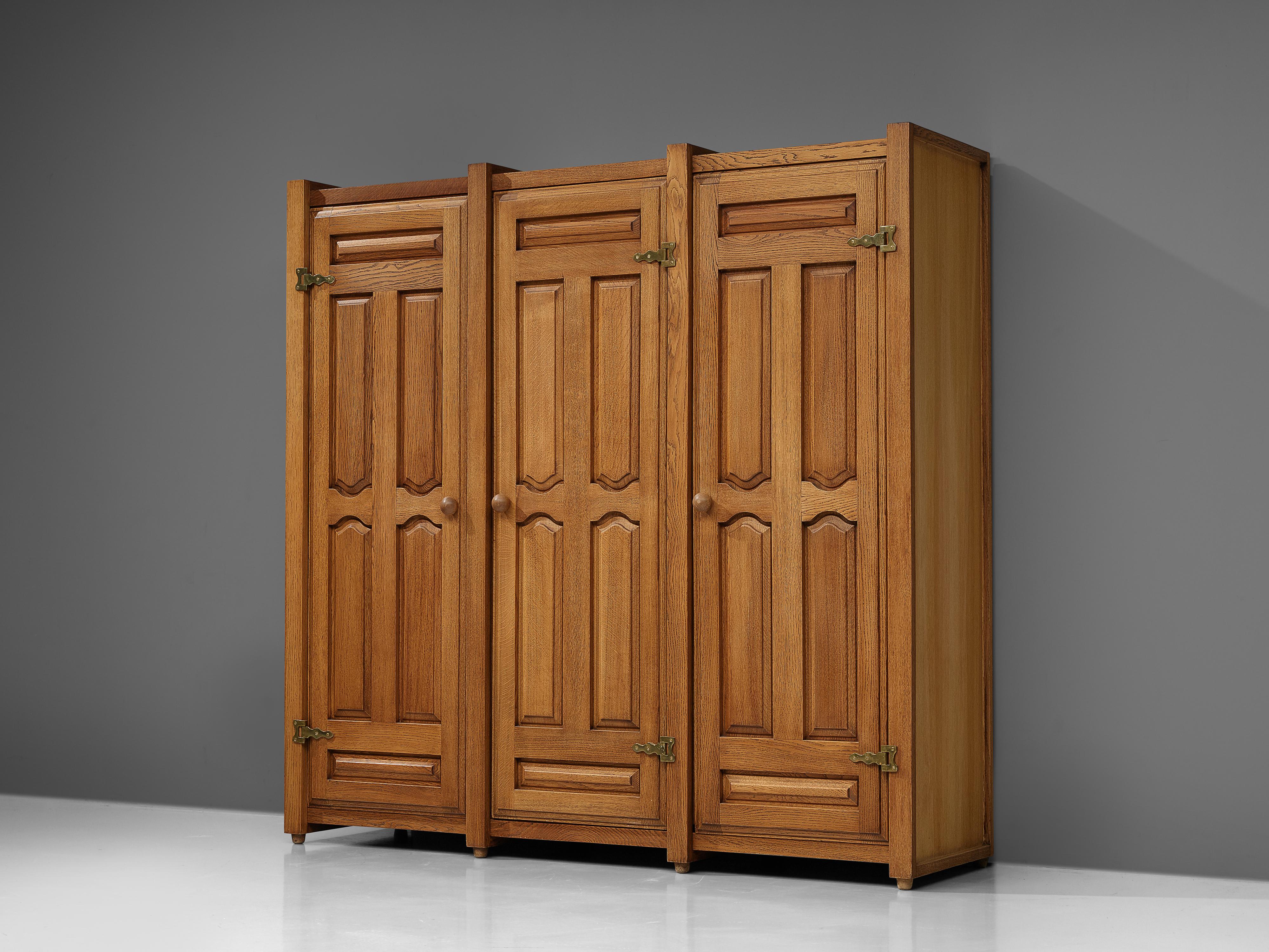 Guillerme et Chambron for Votre Maison, armoire or wardrobe, oak, brass, France, 1960s

This charming wardrobe is a good example of excellent woodworking by virtue of the graphical designed door panels illustrating geometrical wooden carvings, which