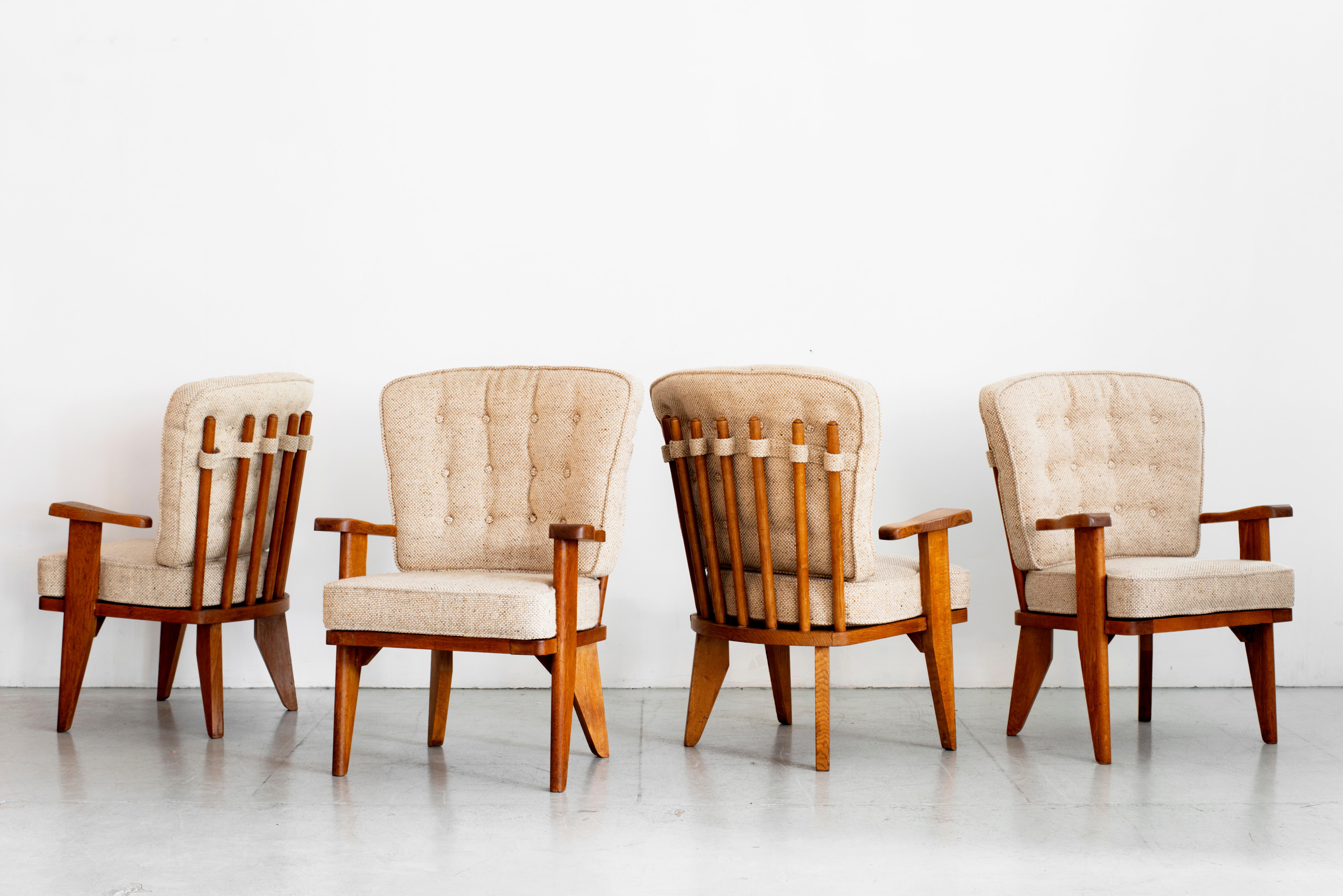 Incredible pair of armchairs chairs by Guillerme et Chambron.
Oak chairs with signature spindle back and great angled legged profile. 
Newly upholstered in textured oatmeal wool.
Two pairs available!