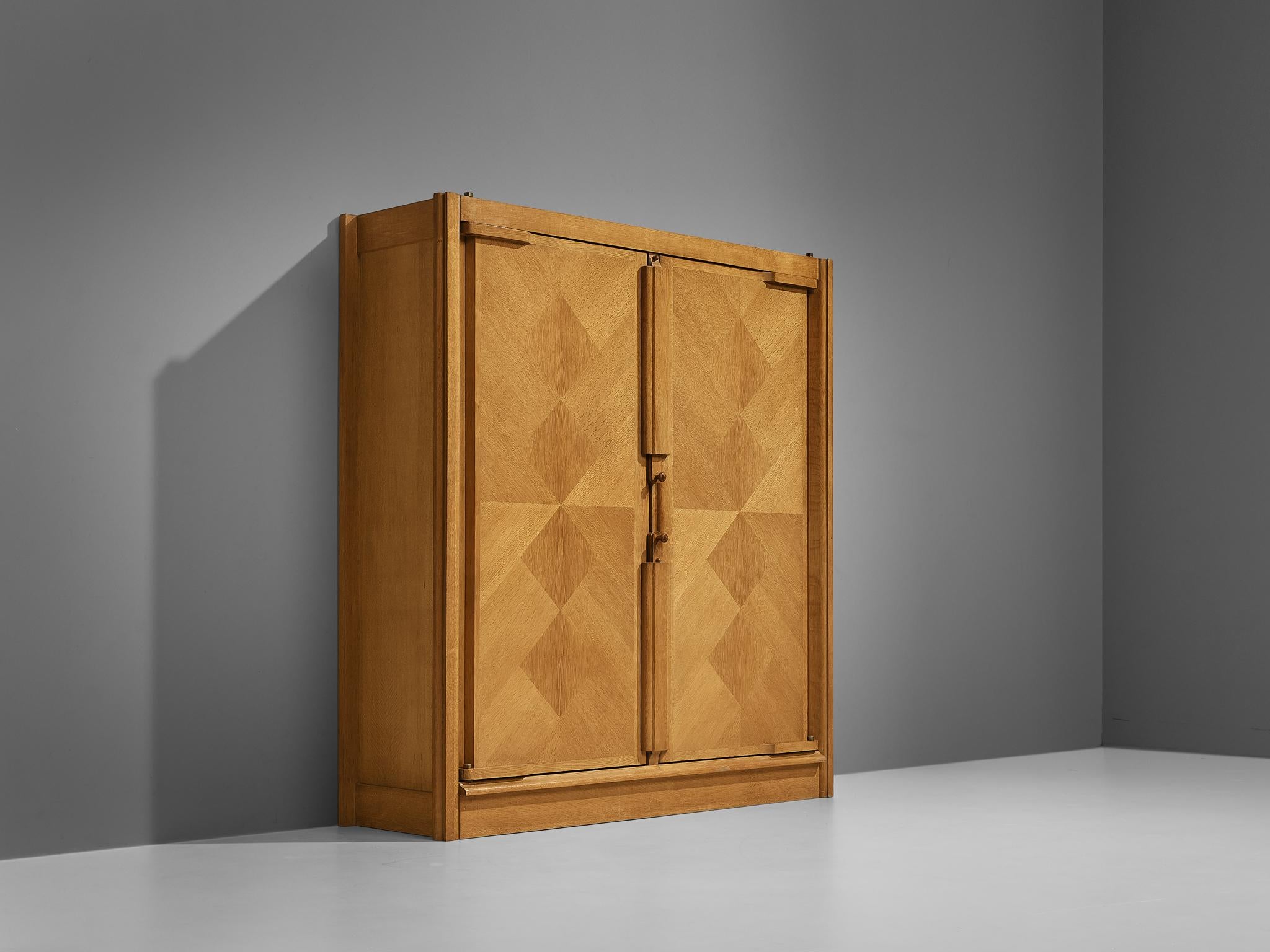 Guillerme et Chambron, wardrobe, oak, France, 1960s

This wardrobe is designed by Guillerme and Chambron and features two inlayed doors. The armoire is equipped with shelves and a cloth rack. It has the characteristic traits of the French designer