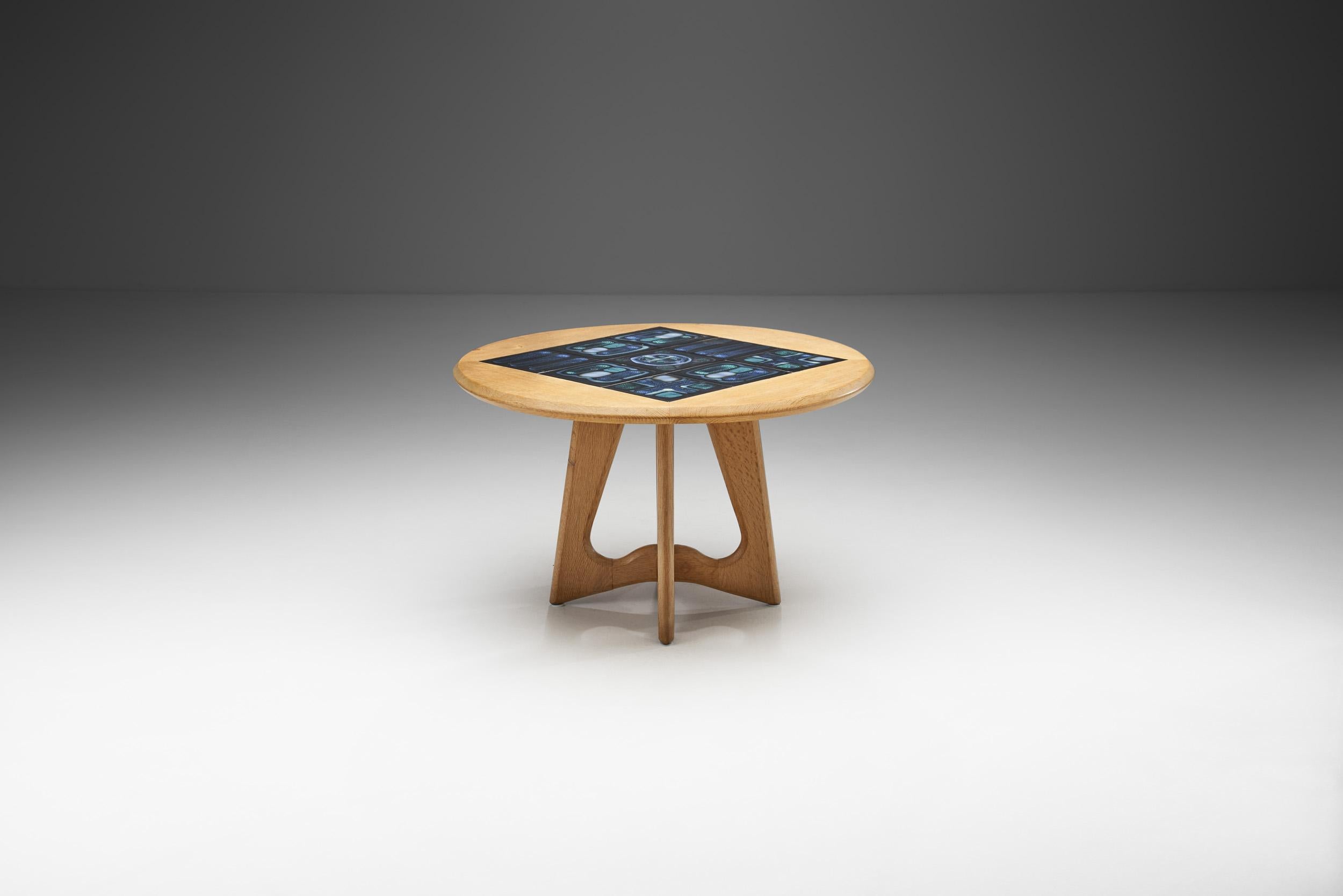Cette brillante table basse avec faïence conçue par le céramiste de renommée mondiale Boleslav Danikovski, est une pièce qui se caractérise par le génie du design de Robert Guillerme et Jacques Chambron. Il représente visuellement la raison même