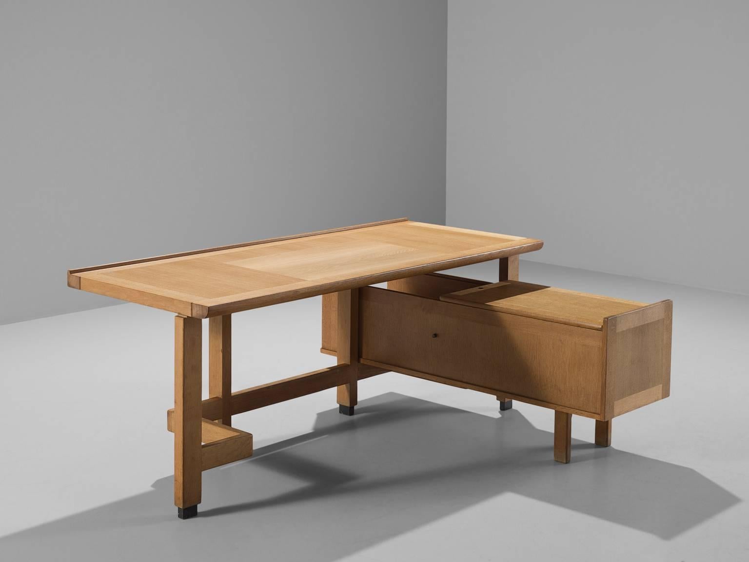 Corner desk in oak by Guillerme et Chambron, France, 1960s. 

Corner desk by French designer duo Guillerme and Chambron. This executive desk shows the fine craftsmanship and line work that characterizes the work of this designer duo. The stained oak