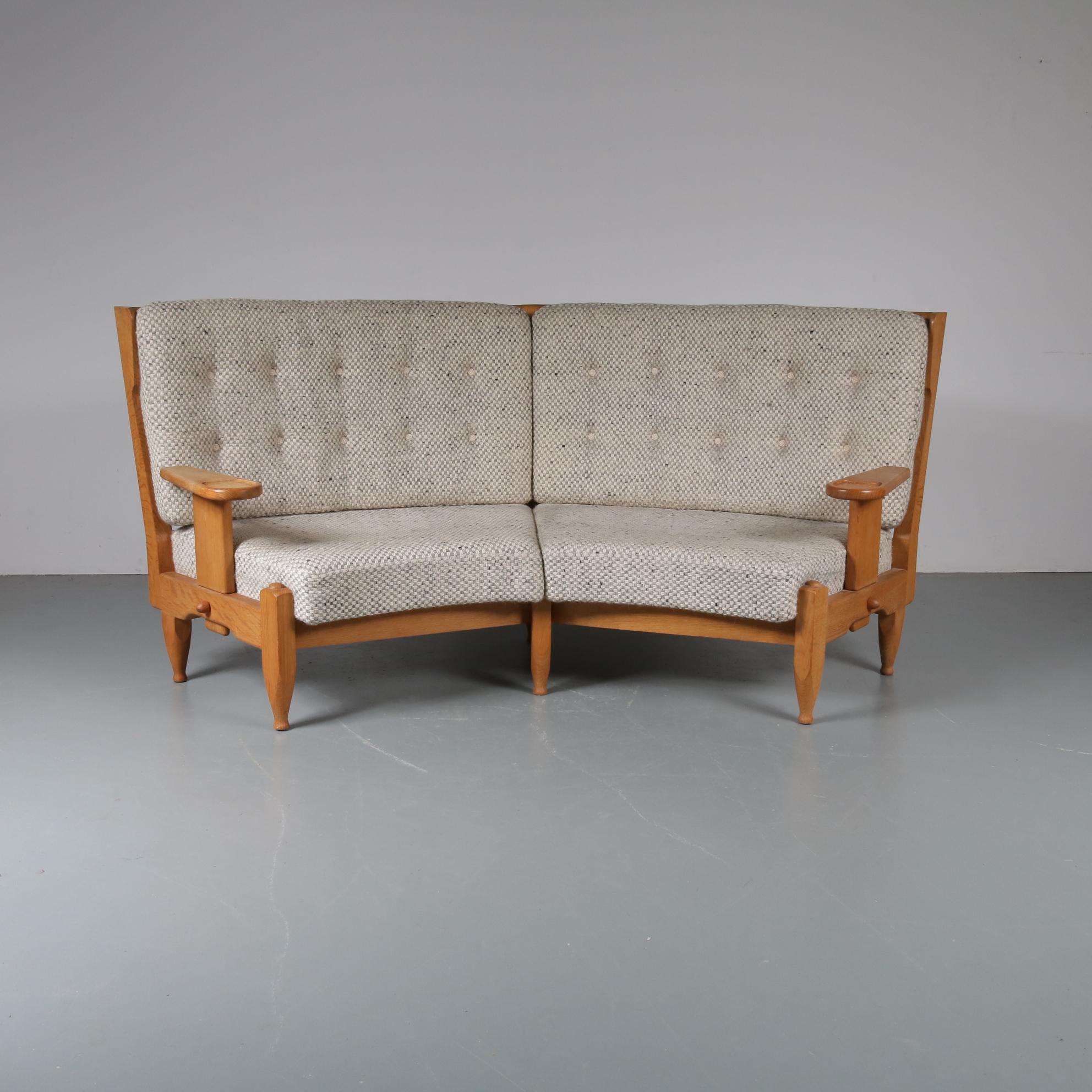 A beautiful settee / corner sofa by Guillerme et Chambron, manufactured in France in the 1940s.

Made of high quality natural colored oakwood with a beautiful rustic style and eye-catching geometrical shapes cut out in the back. That eye-catching