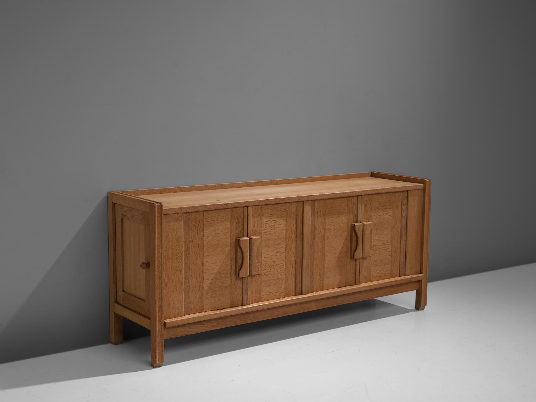 Guillerme et Chambron for Votre Maison, sideboard, oak, France, 1960s.

This quite solid cabinet holds beautiful inlayed woodwork. These graphical patterns are commonly used by Guillerme & Chambron. The sideboard consists of two storage units with