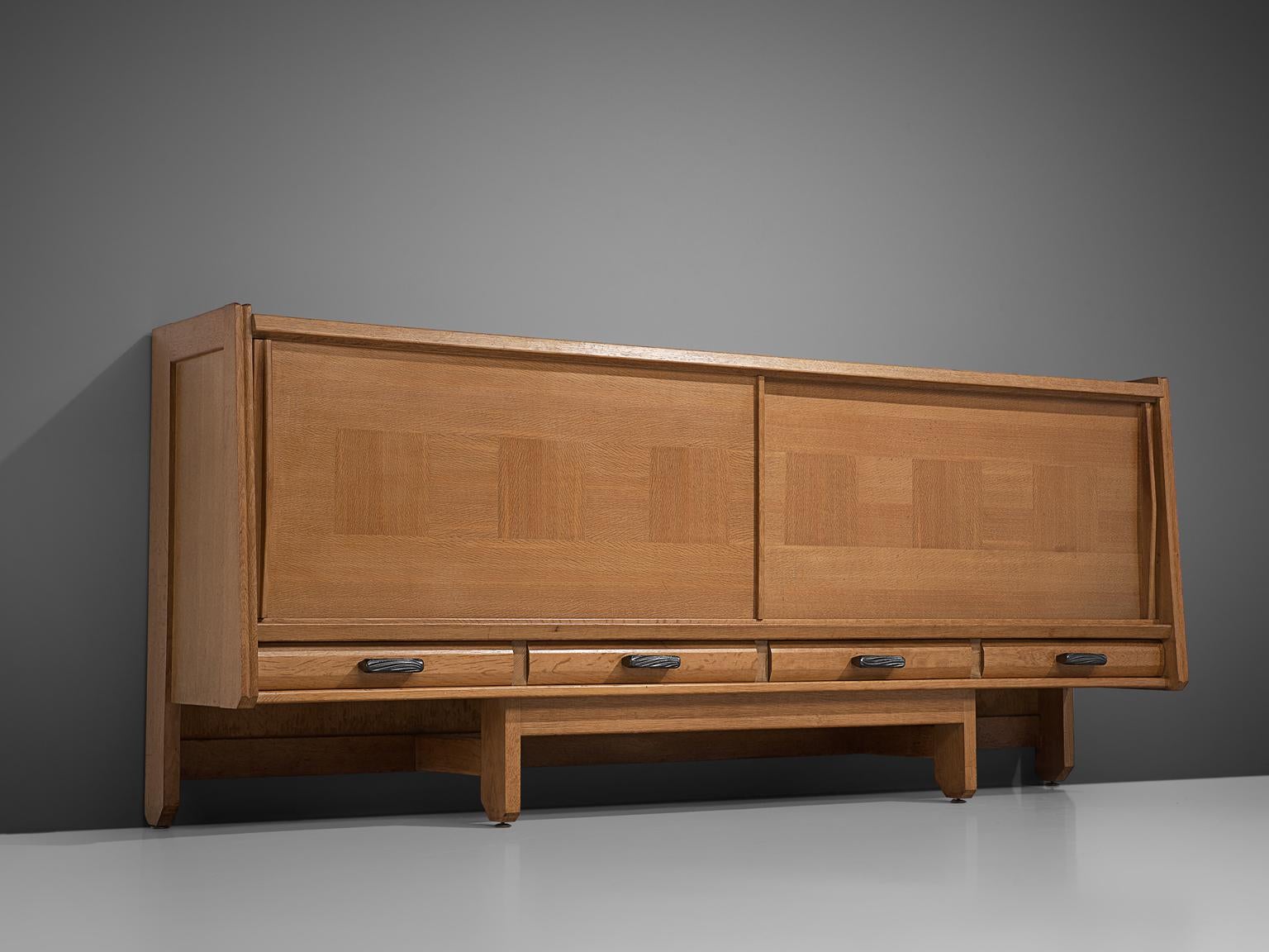 Guillerme et Chambron for Votre Maison, credenza, oak, France, 1960s. 

A sideboard with two sliding doors by French designer duo Guillerme and Chambron. This quite solid cabinet holds beautiful inlaid woodwork. Underneath the sliding doors there