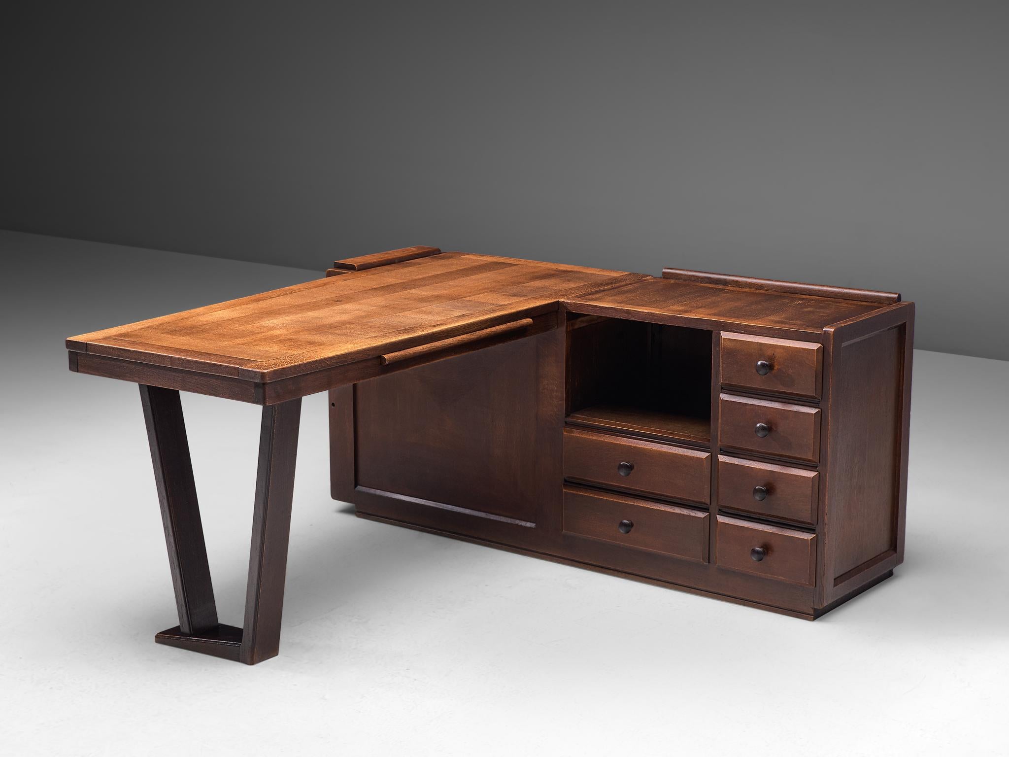 Guillerme et Chambron, desk, dark stained oak, France, 1950s.

Corner desk by French designer duo Guillerme and Chambron. This executive desk shows the fine craftsmanship and line work that characterizes the work of this designer duo. The stained