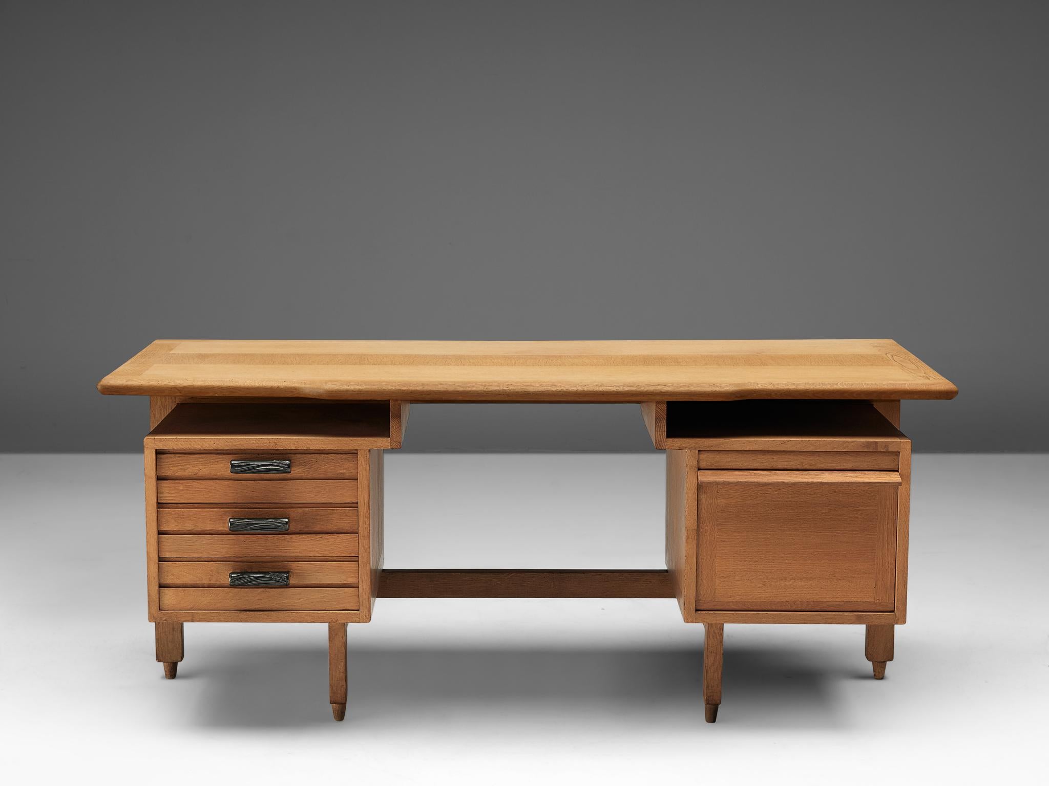 Guillerme et Chambron, desk, oak, France, 1950s.

This desk has a large work surface and are equipped with plenty of storage space due well decorated drawers with ceramic handles on the left and one large compartment on the right to fully enjoy the