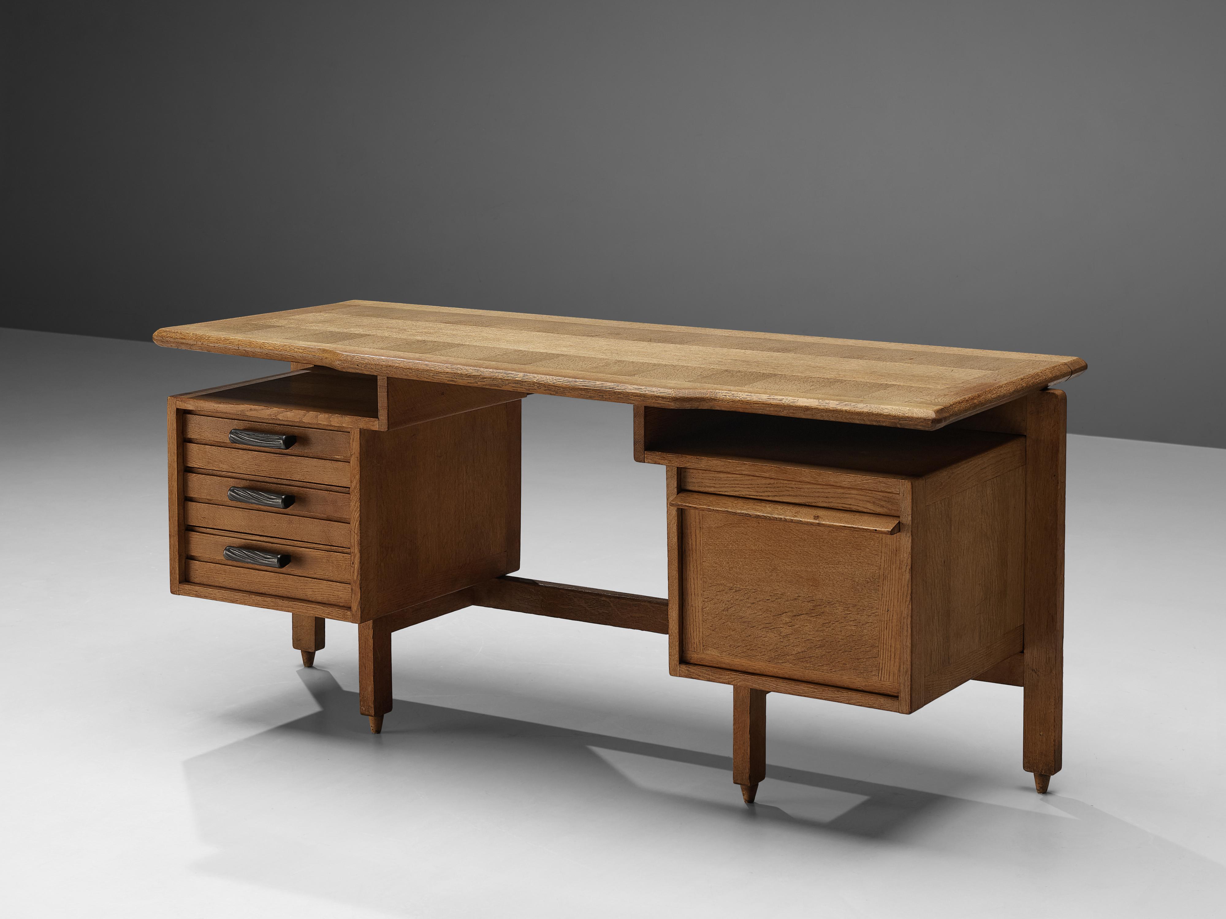 Guillerme et Chambron, desk, oak, France, 1950s

This desk has a large work surface and is equipped with storage space. Two compartments on both sides allow you to store your belongings. An open shelf between top and drawers can be used too. The