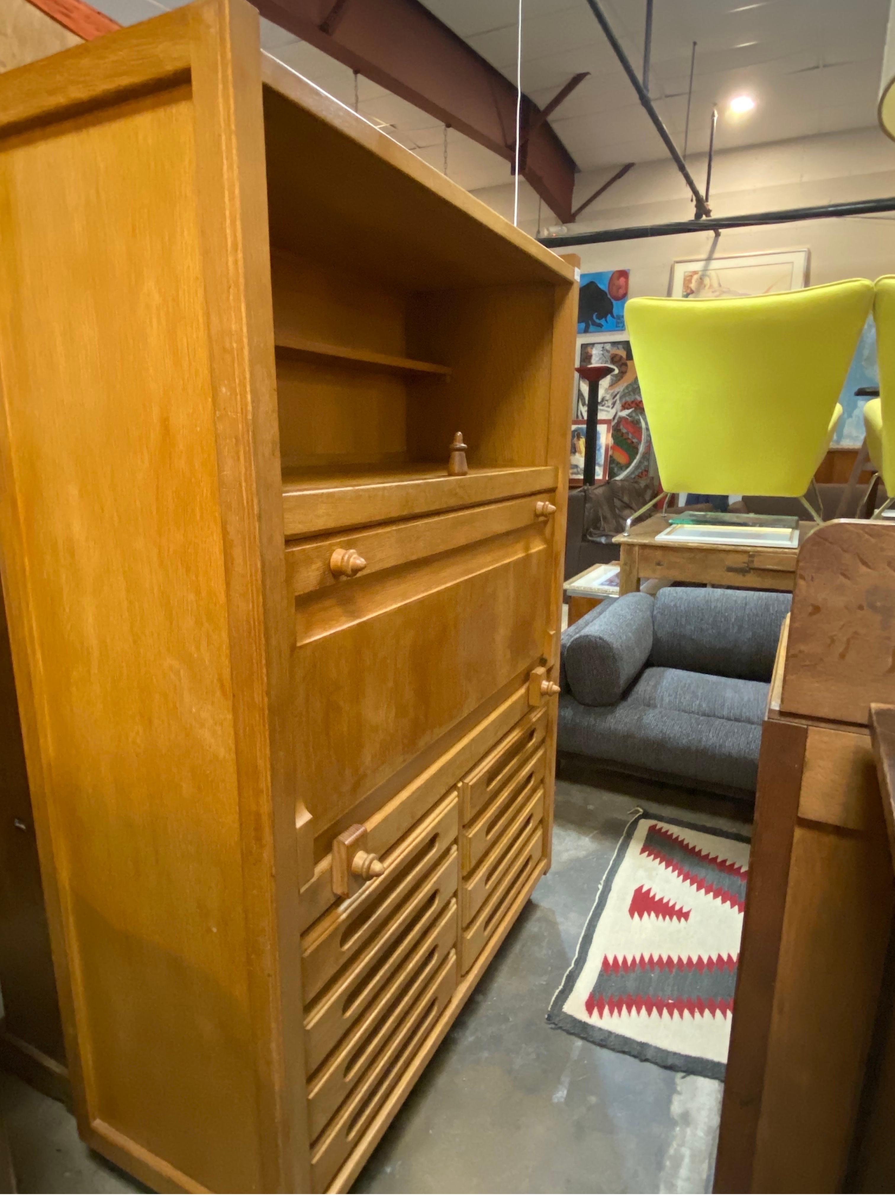 Solid oak mid-century modern drop front cabinet designed by Guillerme et Chambron for Votre Maison, France, circa 1960s. This distinctive cabinet exemplifies Guillerme's ability to create design pieces  that offer function and aesthetic. The cabinet