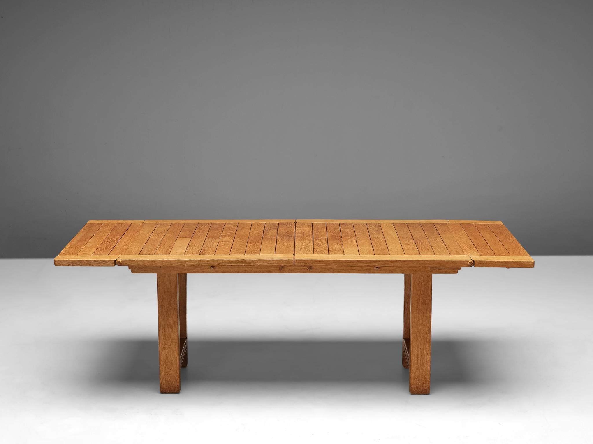 Guillerme & Chambron, extendable dining table model 'Bourbonnais', in oak, France, 1970s.

The solid frame together with the extendible leaves are in a very good working condition. The leaves are 'hidden' under the top and this table could easily be