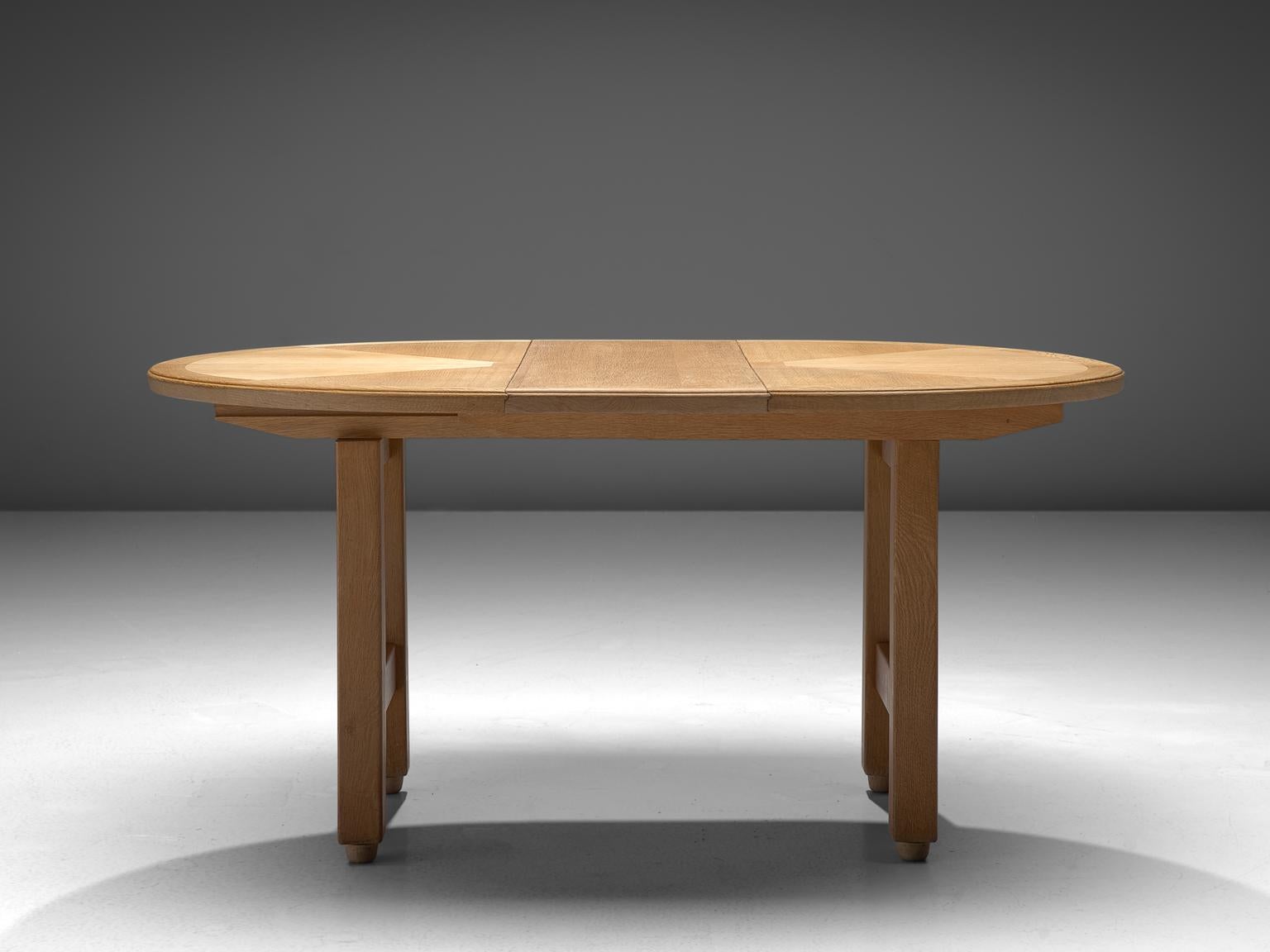 Guillerme et Chambron, extendable dining table, oak, 1960s.

Oval shaped dining table with inlayed top. This extendable table in solid oak comes with two optional leaves, which makes it a very versatile item. The sculptural two legged base has the
