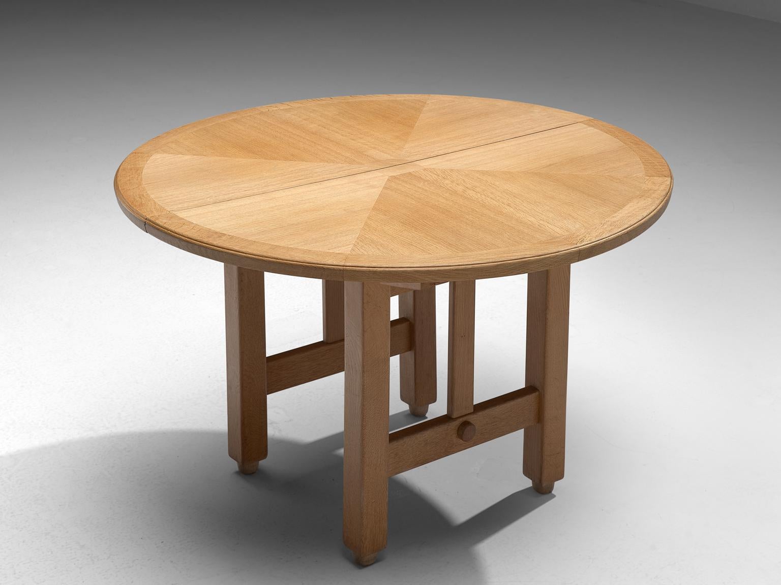 Guillerme et Chambron, extendable dining table, oak, 1960s.

Round shaped dining table with inlayed top. This extendable table in solid oak comes with an optional leaf, which makes it a very versatile item. The sculptural two legged base has the