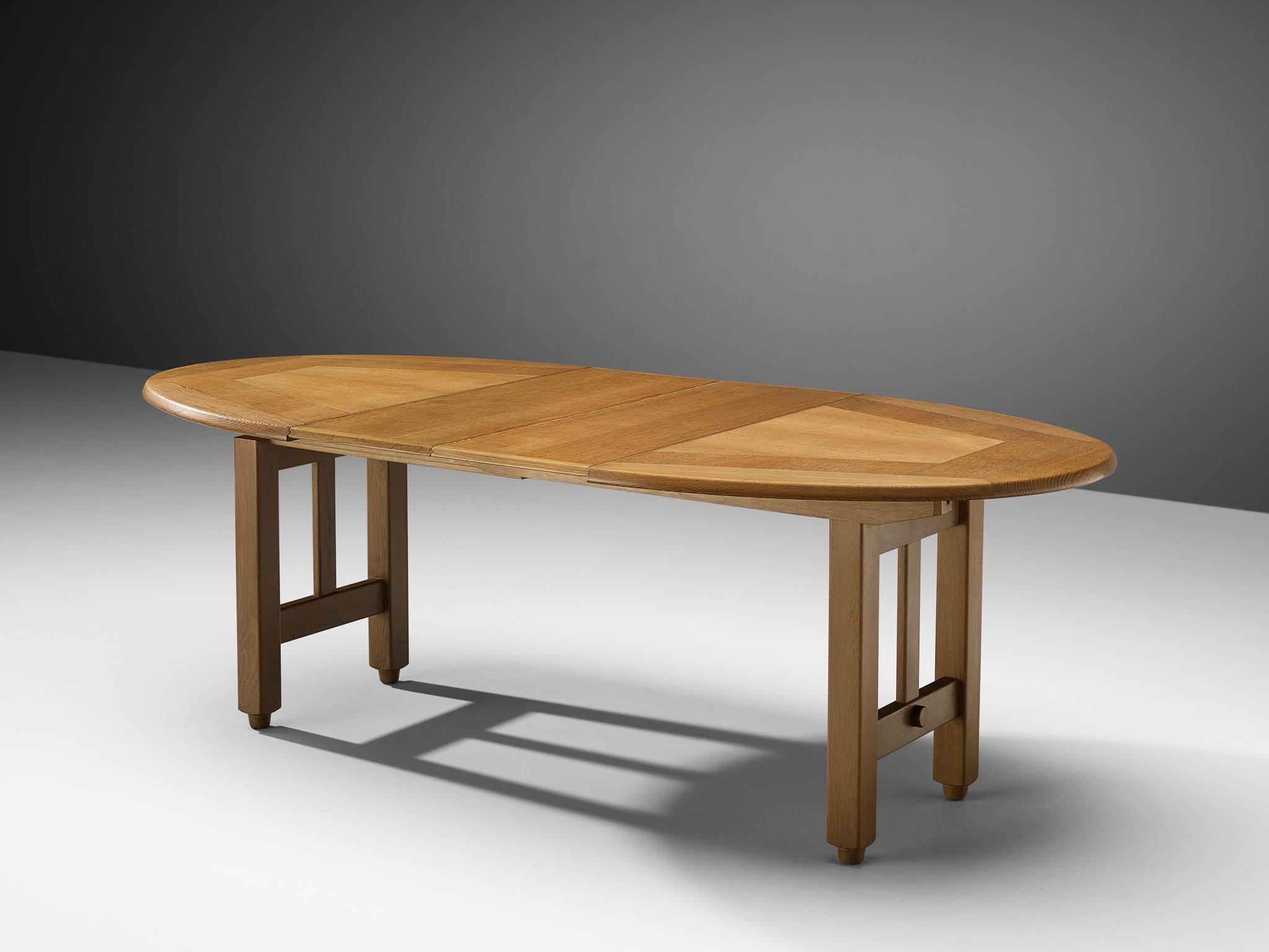 Guillerme et Chambron, extendable dining table, oak, 1960s

Round shaped dining table with inlayed top. This extendable table in solid oak comes with two additional leaves, which makes it a very versatile item. The sculptural two legged base has the