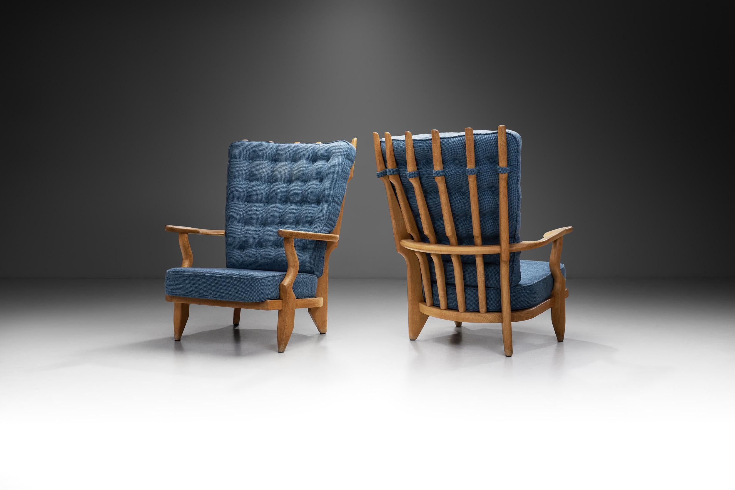 Ces chaises longues 'Grand Repos' de Guillerme et Chambron présentent un beau contraste entre la structure en bois de chêne clair et l'élégant tissu bleu des coussins. Avec un cadre en bois massif, le support du dossier est constitué de six fuseaux