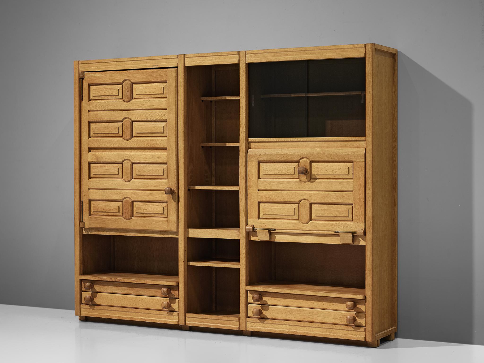 Guillerme and Chambron, highboard, oak, France, 1960s.

This case piece is designed by Guillerme and Chambron and features geometric engravings on the many different storage spaces such like drawers and shelves. The piece is typical for the design