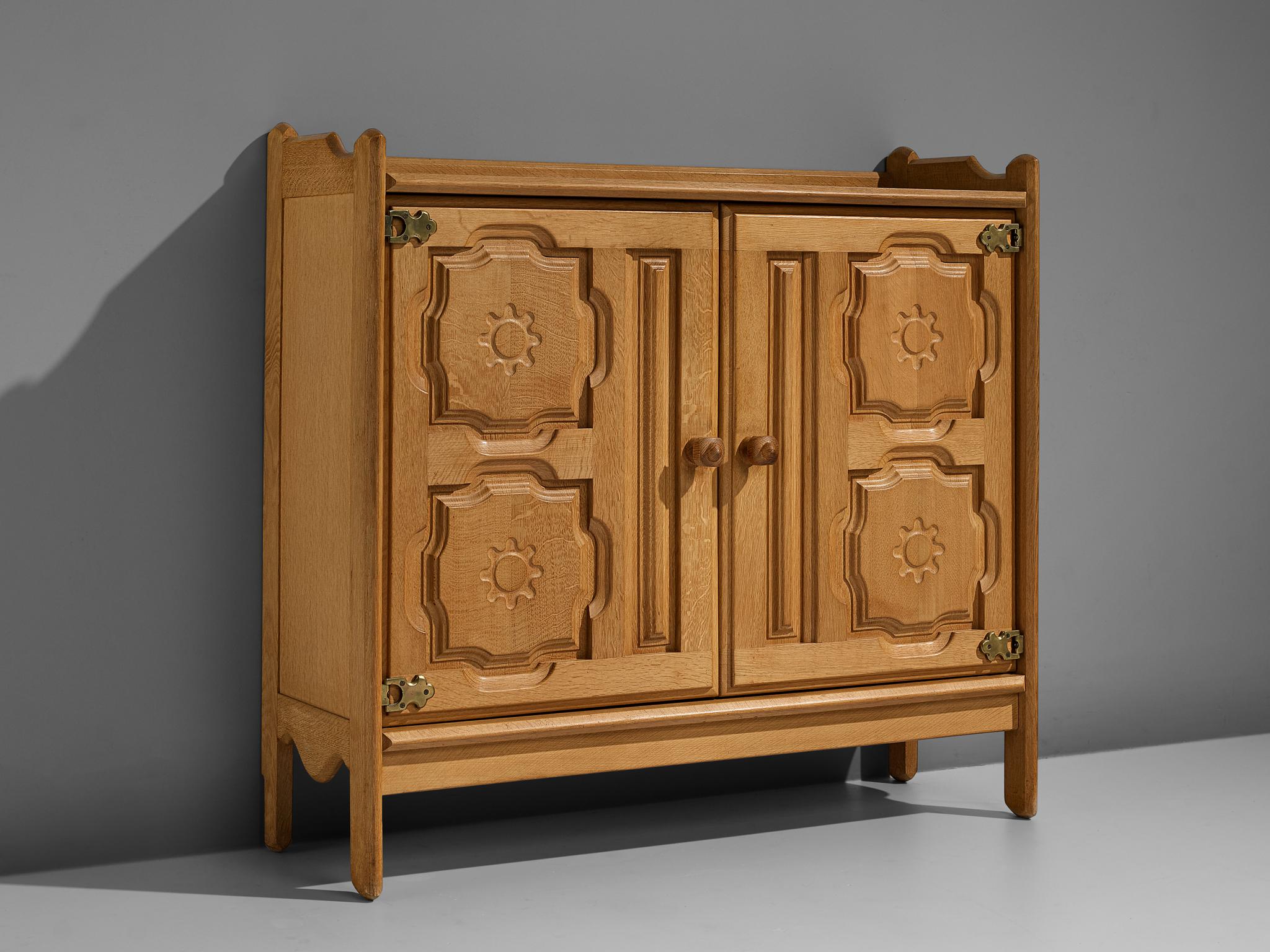 Guillerme et Chambron, high board, oak, brass, France, 1950s.

This highboard by French designer duo Guillerme et Chambron features beautiful ornamented doors. Both oak doors are carved with flowerlike ornaments. Round wooden handles access the