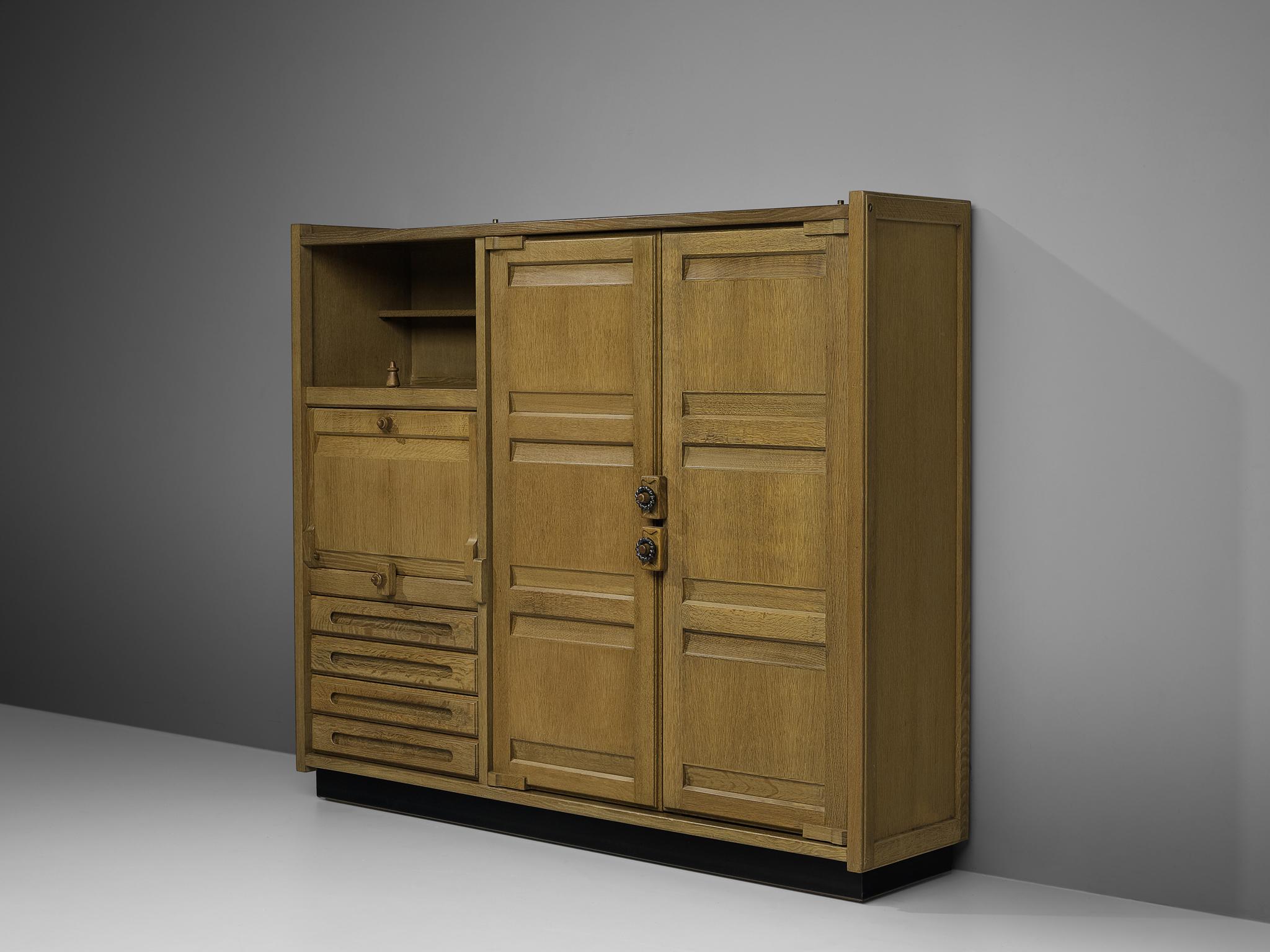 Guillerme et Chambron, highboard, green stained oak, France, 1960s

Versatile highboard by French designer duo Guillerme et Chambron. Two high doors and one colum with drawers, an open and a closed shelf are allowing great storage facilities.