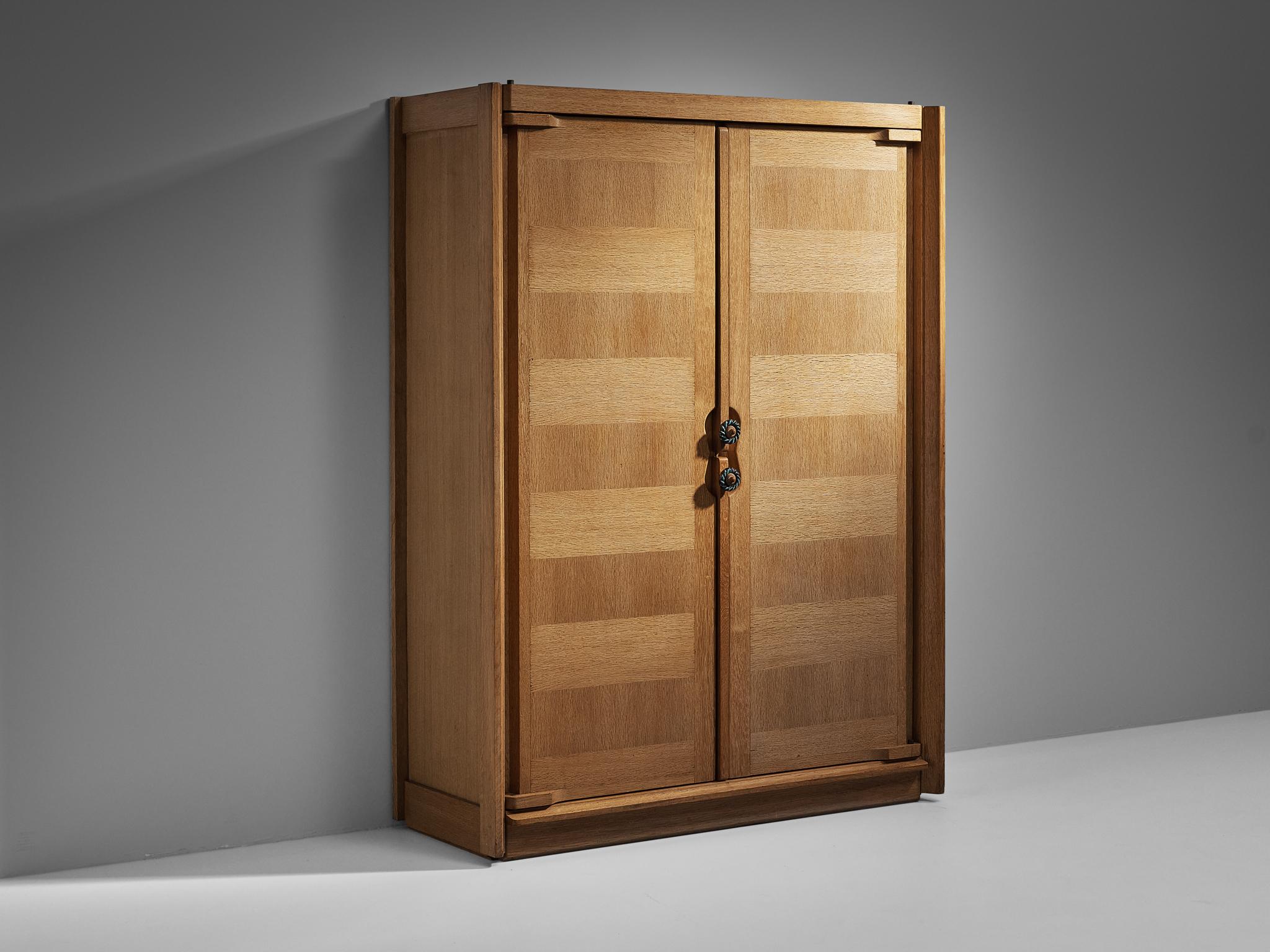 Guillerme et Chambron for Votre Maison, armoire, oak, ceramic, France, 1960s. 

This case piece is designed by Guillerme and Chambron and features geometric oak inlays, which is characteristic for the French duo. The wardrobe is equipped with