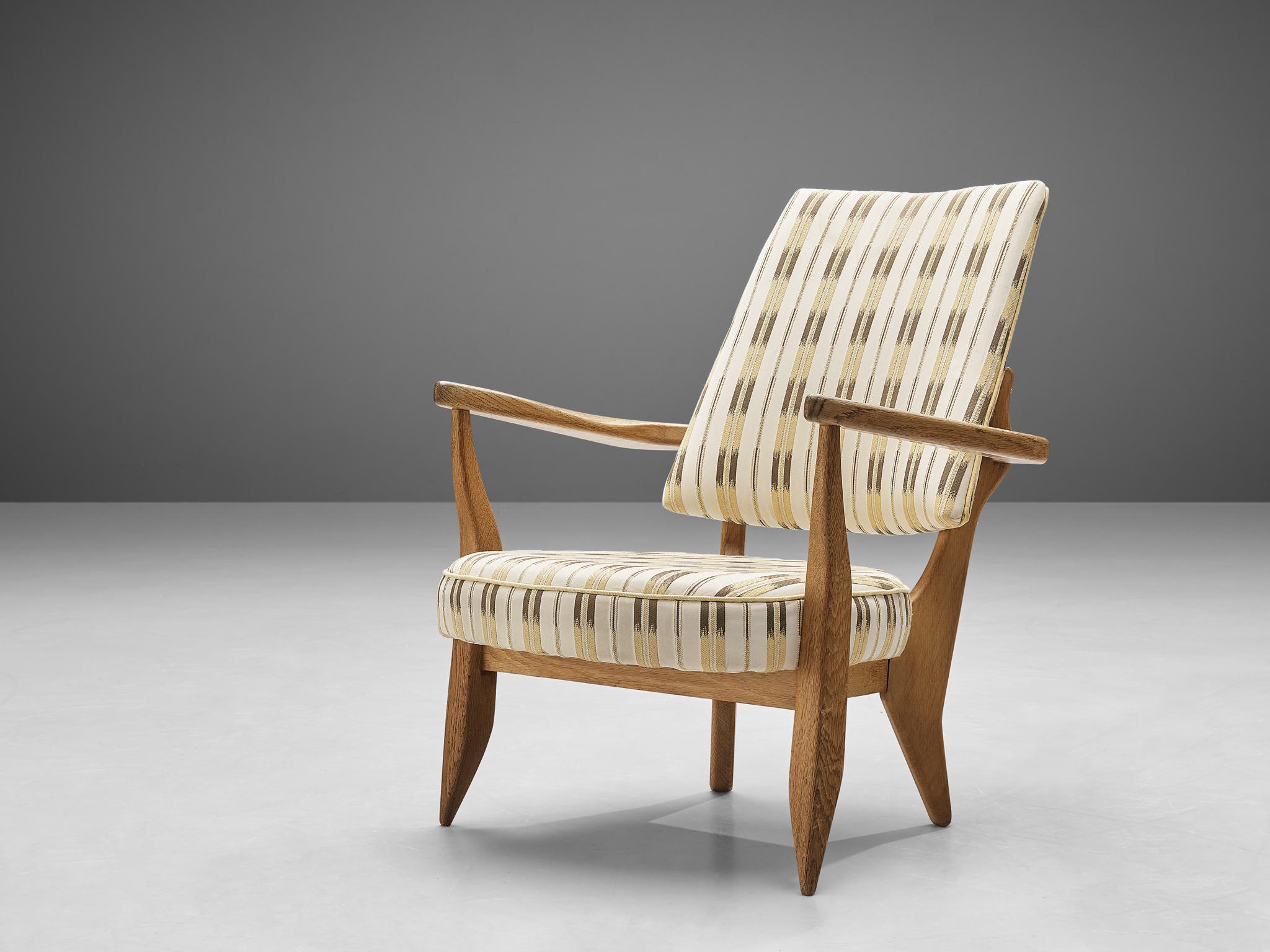 Guillerme et Chambron, easy chair, patterned fabric, oak, France, 1950s 

This sculptural easy chair by Guillerme et Chambron is very well executed and made out of solid, carved oak. The comfortable armchair features an interesting open