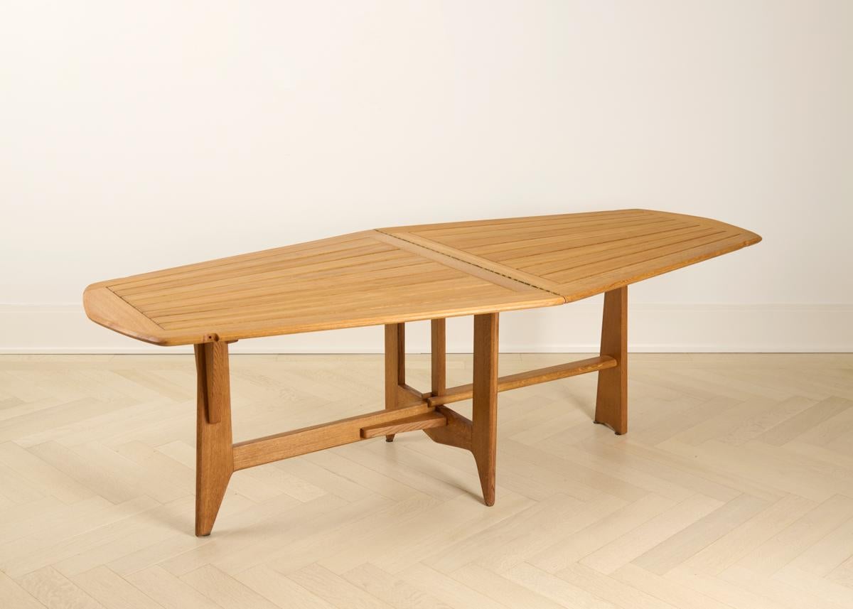 An extendable limed oak dining table. At its longest (as pictured) it is 89