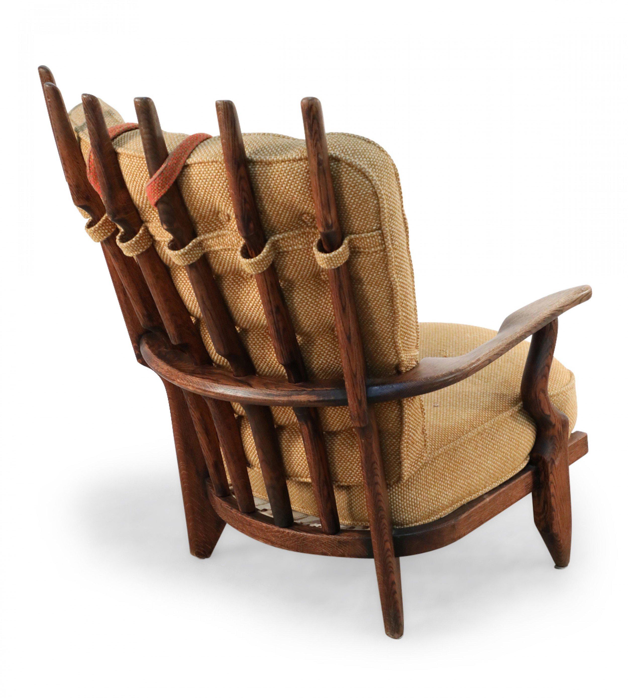 Mid-century French Grand-Repos oak armchair with six fanning back slats and beige button tufted upholstery with an orange head cushion (GUILLERME ET CHAMBRON).
      