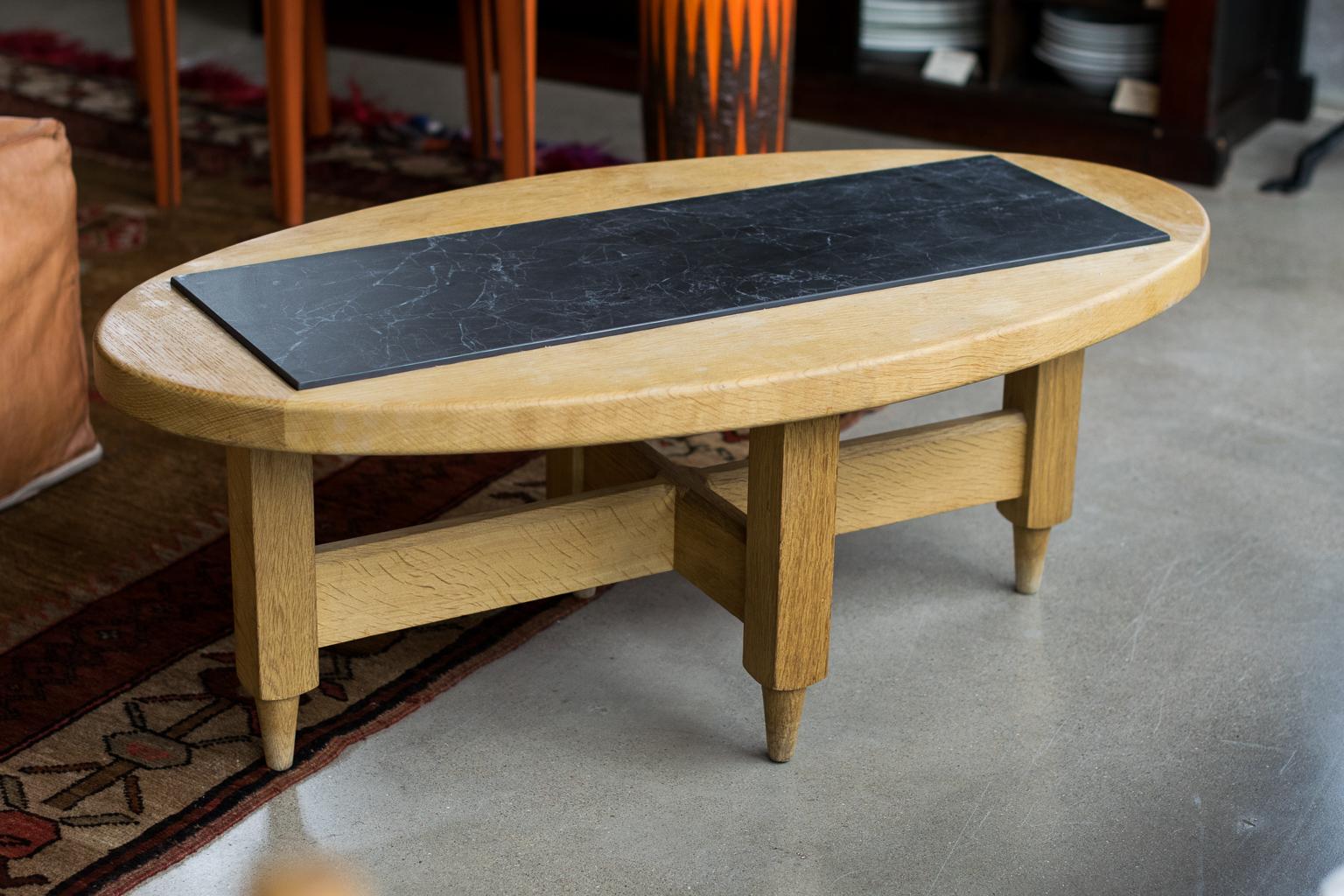 Oval oak cocktail table with inset gray center panel. The table by the French duo Jacques Chambron and Robert Guillerme, known for their sculptural designs in French white oak from the post war period all the way through the 1970s. The original