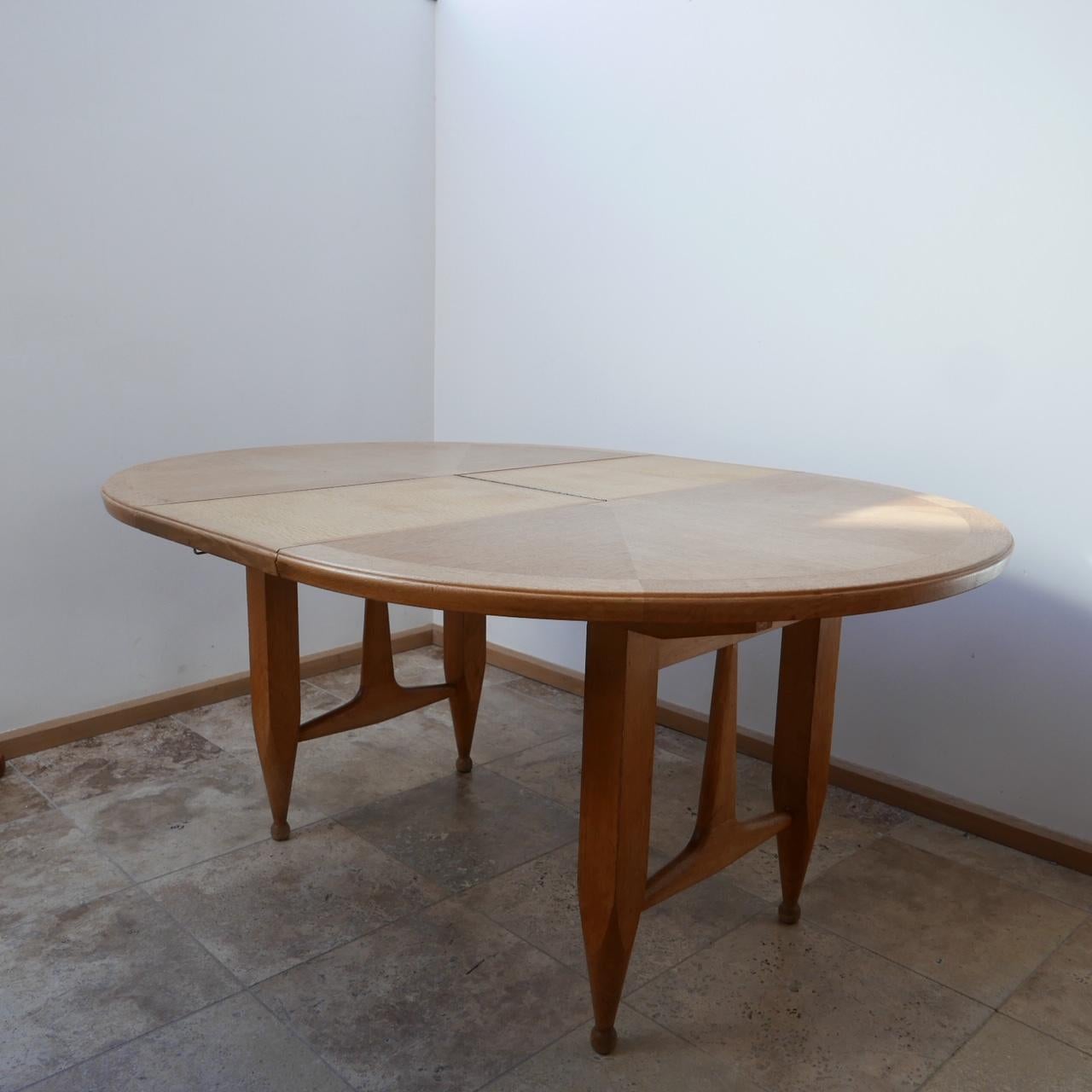 An adjustable dining table by design legends Guillerme et Chambron. 

France, c1970s. 

One extendable leaf that folds out on brass hinges. 

Good vintage condition. 

Dimensions: 120 L x 74 H x 120 W x 157 L when extended. 

Delivery: