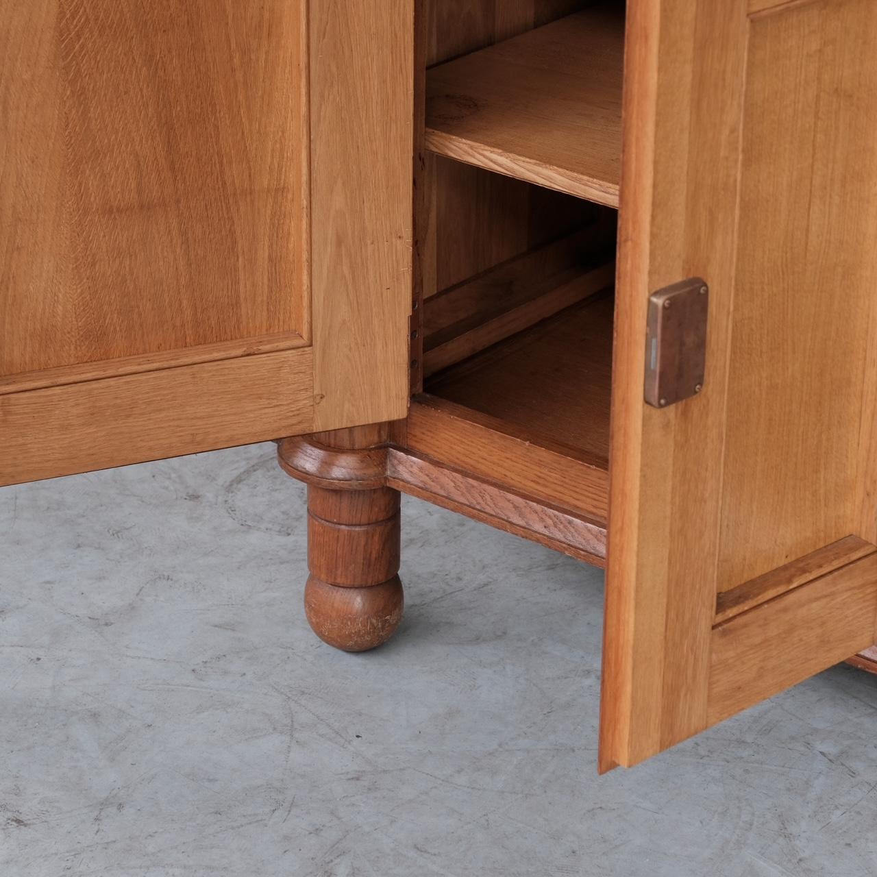 A scarce cabinet by Guillerme et Chambron. 

Oak, France, c1960s. 

'Bouvine' model. 

Two secret side doors hide additional storage, internally there are shelves.

Clever wooden locking mechanism, with thick brass exposed hinges. 

Good