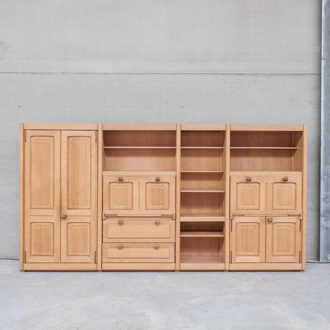 A substantial multi use oak cabinet and shelving unit by esteemed French designers Guillerme et Chambron. 

France, c1960s. 

A multi-faceted unit, with two large doors to the left, hiding shelving, drawers and a drop down cupboard to the